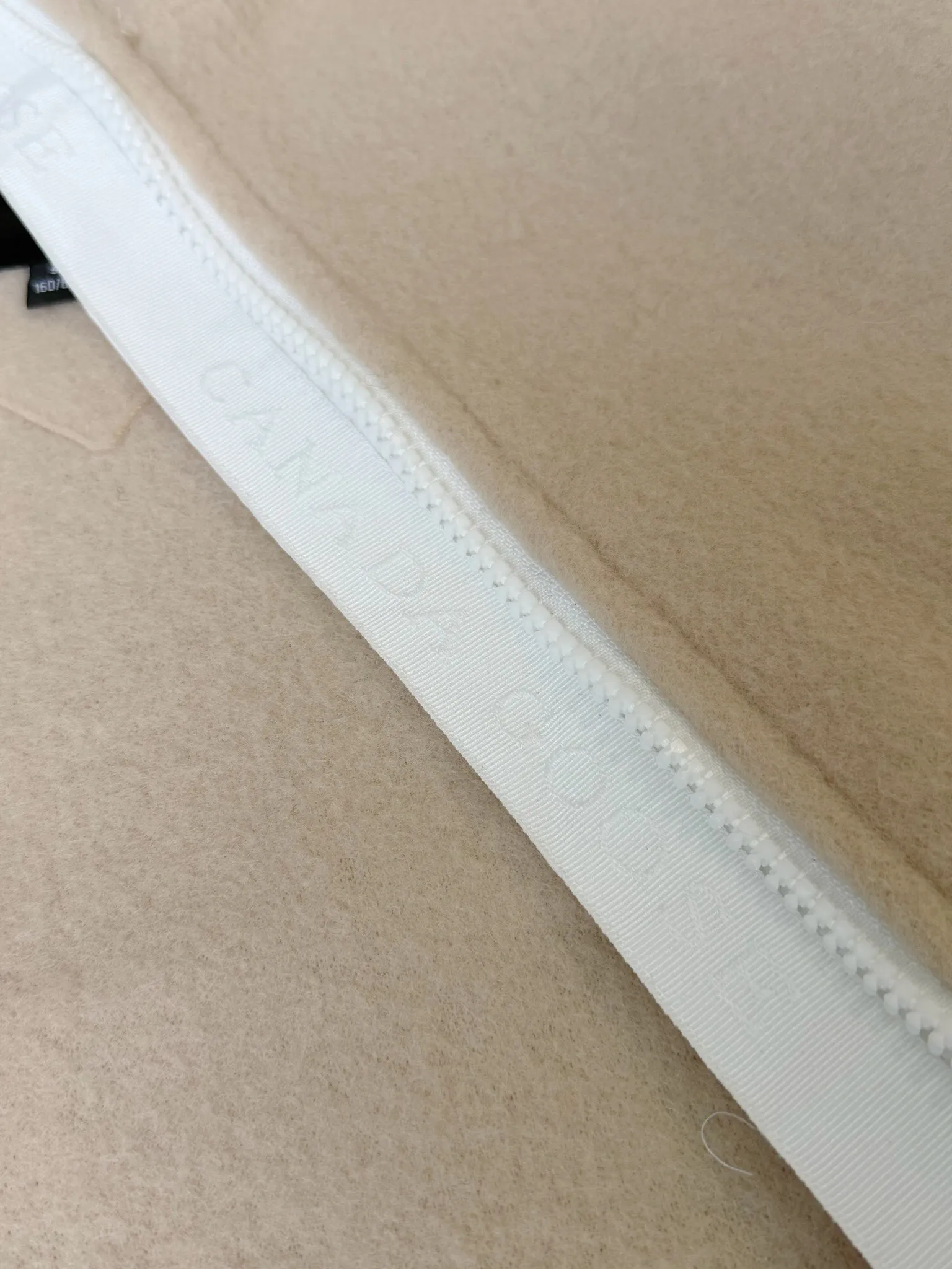 大鹅/Canada Goose抓绒羊毛饰章连帽夹克外套 面料选择: 以羊毛为主体,加入极少量氨纶和聚酯纤维混纺而成的羊毛抓绒面料。羊毛作为核心天然成分,提供无与伦比的温度调节、抑菌防臭和亲肤感。少量氨纶的喂入赋予了面料一定的四向弹性,日常活动时毫无束缚感。作为抓绒结构的基础,聚酯纤维增强了面料的耐久性、抗皱性和快干性,它构成了抓绒的蓬松感,并提供锁住空气等功能。 细节1: 衣袖和下摆采用2乘2罗纹收口,其强大的弹性,可以紧密贴合不同粗细的手腕和腰部,形成一个有效的‘密封’,防止冷风倒灌。在多次拉伸和使用后仍能保持原有形状,不易松垮变形。且罗纹袖口能传递一种设计感,强化视觉美观度。 细节2: 兜帽设计与松紧扣的搭配提升穿戴时的保暖度与防风性能。 辅料:定制弹性抽绳松紧扣定制拉链吊坠定制臂章 尺码:S M L 颜色:黑 灰 咖 米 粉