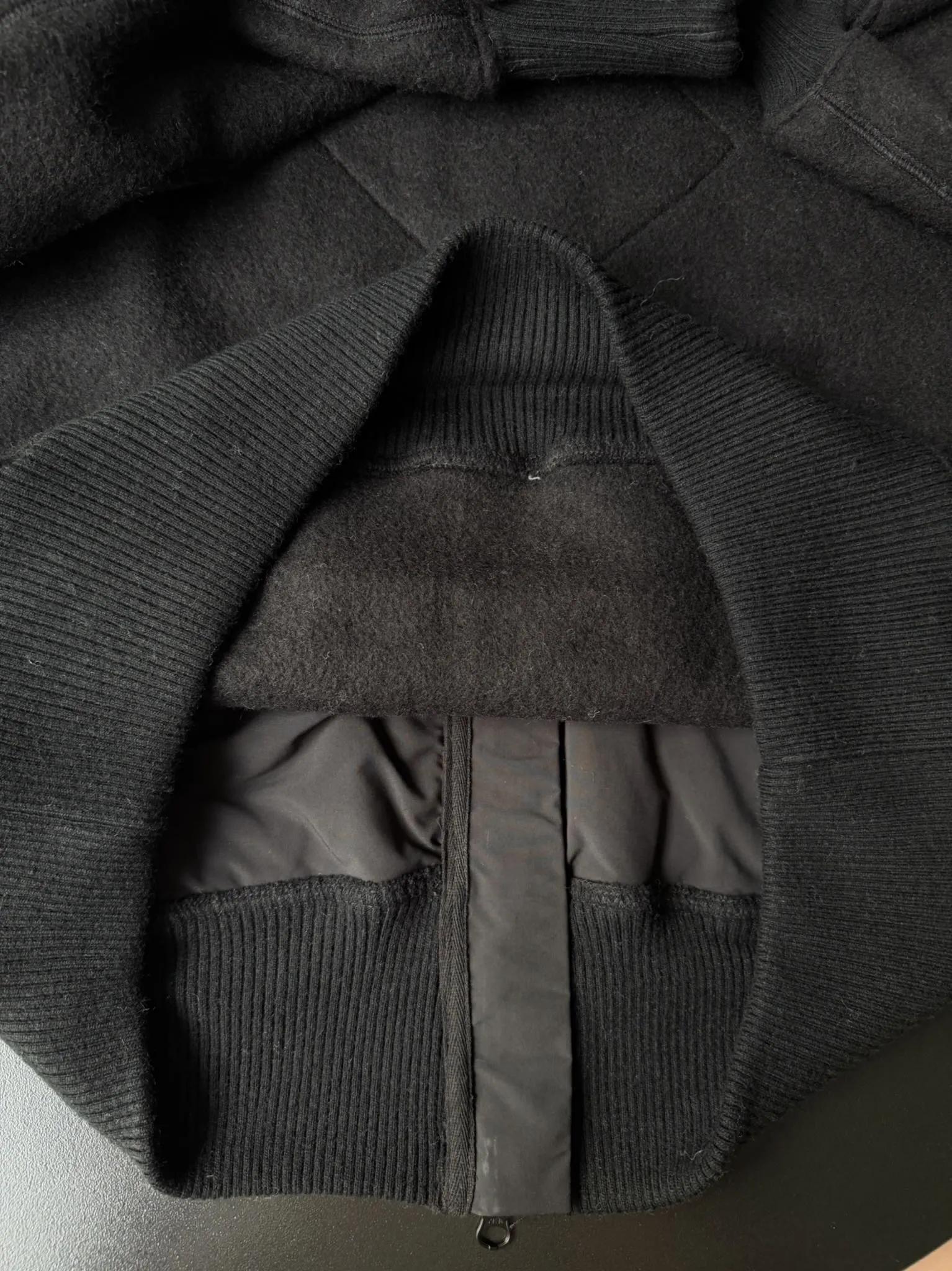 大鹅/Canada Goose抓绒羊毛饰章连帽夹克外套 面料选择: 以羊毛为主体,加入极少量氨纶和聚酯纤维混纺而成的羊毛抓绒面料。羊毛作为核心天然成分,提供无与伦比的温度调节、抑菌防臭和亲肤感。少量氨纶的喂入赋予了面料一定的四向弹性,日常活动时毫无束缚感。作为抓绒结构的基础,聚酯纤维增强了面料的耐久性、抗皱性和快干性,它构成了抓绒的蓬松感,并提供锁住空气等功能。 细节1: 衣袖和下摆采用2乘2罗纹收口,其强大的弹性,可以紧密贴合不同粗细的手腕和腰部,形成一个有效的‘密封’,防止冷风倒灌。在多次拉伸和使用后仍能保持原有形状,不易松垮变形。且罗纹袖口能传递一种设计感,强化视觉美观度。 细节2: 兜帽设计与松紧扣的搭配提升穿戴时的保暖度与防风性能。 辅料:定制弹性抽绳松紧扣定制拉链吊坠定制臂章 尺码:S M L 颜色:黑 灰 咖 米 粉