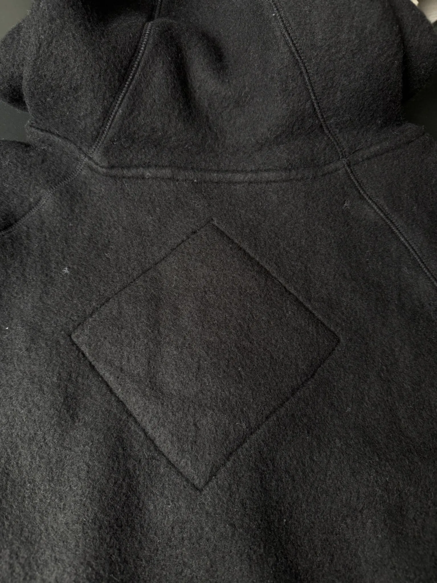 大鹅/Canada Goose抓绒羊毛饰章连帽夹克外套 面料选择: 以羊毛为主体，加入极少量氨纶和聚酯纤维混纺而成的羊毛抓绒面料。羊毛作为核心天然成分，提供无与伦比的温度调节、抑菌防臭和亲肤感。少量氨纶的喂入赋予了面料一定的四向弹性，日常活动时毫无束缚感。作为抓绒结构的基础，聚酯纤维增强了面料的耐久性、抗皱性和快干性，它构成了抓绒的蓬松感，并提供锁住空气等功能。 细节1: 衣袖和下摆采用2乘2罗纹收口，其强大的弹性，可以紧密贴合不同粗细的手腕和腰部，形成一个有效的&lsquo;密封&rsquo;,防止冷风倒灌。在多次拉伸和使用后仍能保持原有形状，不易松垮变形。且罗纹袖口能传递一种设计感，强化视觉美观度。 细节2: 兜帽设计与松紧扣的搭配提升穿戴时的保暖度与防风性能。 辅料:定制弹性抽绳松紧扣定制拉链吊坠定制臂章 尺码：S M L 颜色：黑 灰 咖 米 粉