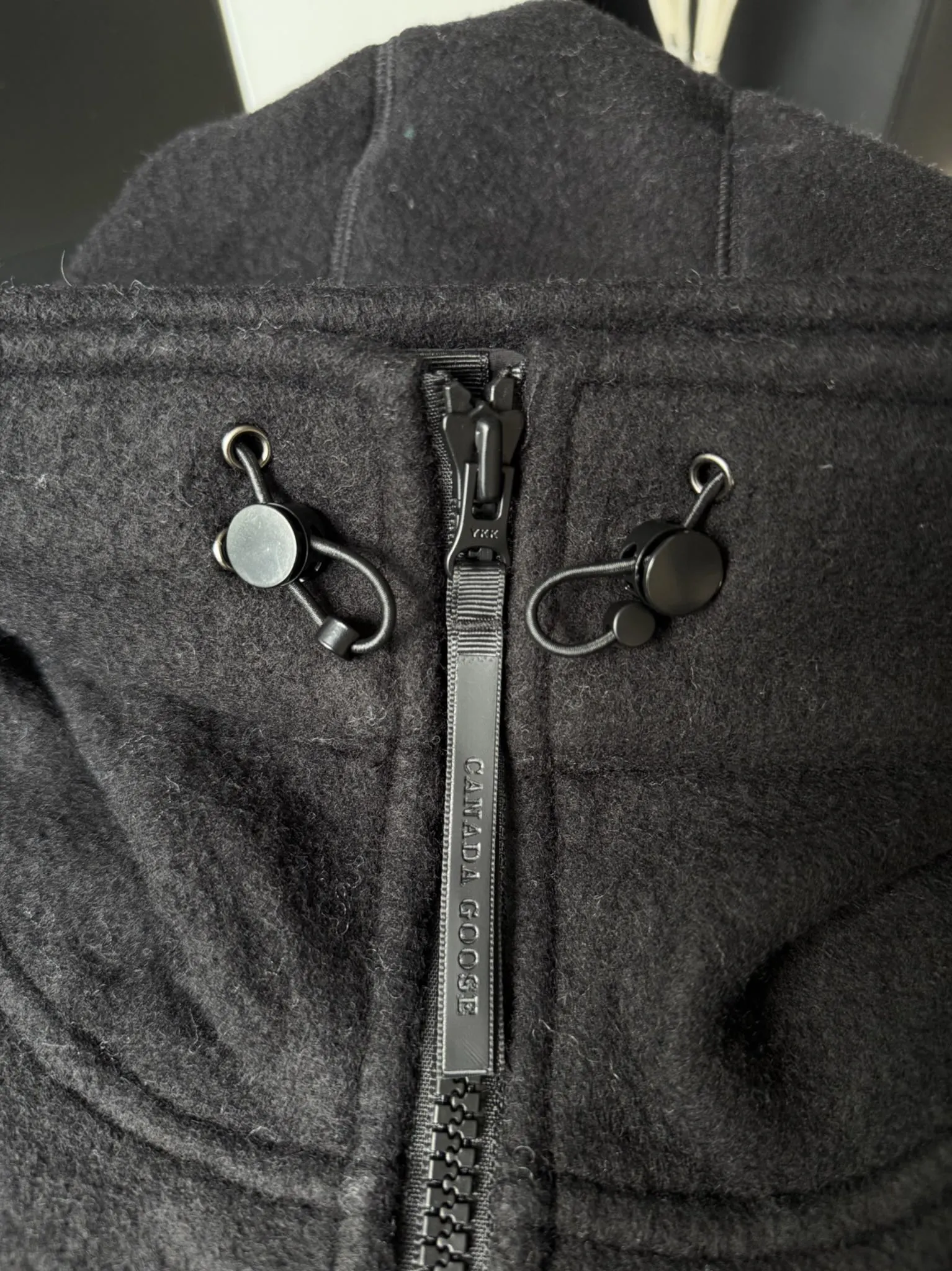 大鹅/Canada Goose抓绒羊毛饰章连帽夹克外套 面料选择: 以羊毛为主体,加入极少量氨纶和聚酯纤维混纺而成的羊毛抓绒面料。羊毛作为核心天然成分,提供无与伦比的温度调节、抑菌防臭和亲肤感。少量氨纶的喂入赋予了面料一定的四向弹性,日常活动时毫无束缚感。作为抓绒结构的基础,聚酯纤维增强了面料的耐久性、抗皱性和快干性,它构成了抓绒的蓬松感,并提供锁住空气等功能。 细节1: 衣袖和下摆采用2乘2罗纹收口,其强大的弹性,可以紧密贴合不同粗细的手腕和腰部,形成一个有效的‘密封’,防止冷风倒灌。在多次拉伸和使用后仍能保持原有形状,不易松垮变形。且罗纹袖口能传递一种设计感,强化视觉美观度。 细节2: 兜帽设计与松紧扣的搭配提升穿戴时的保暖度与防风性能。 辅料:定制弹性抽绳松紧扣定制拉链吊坠定制臂章 尺码:S M L 颜色:黑 灰 咖 米 粉