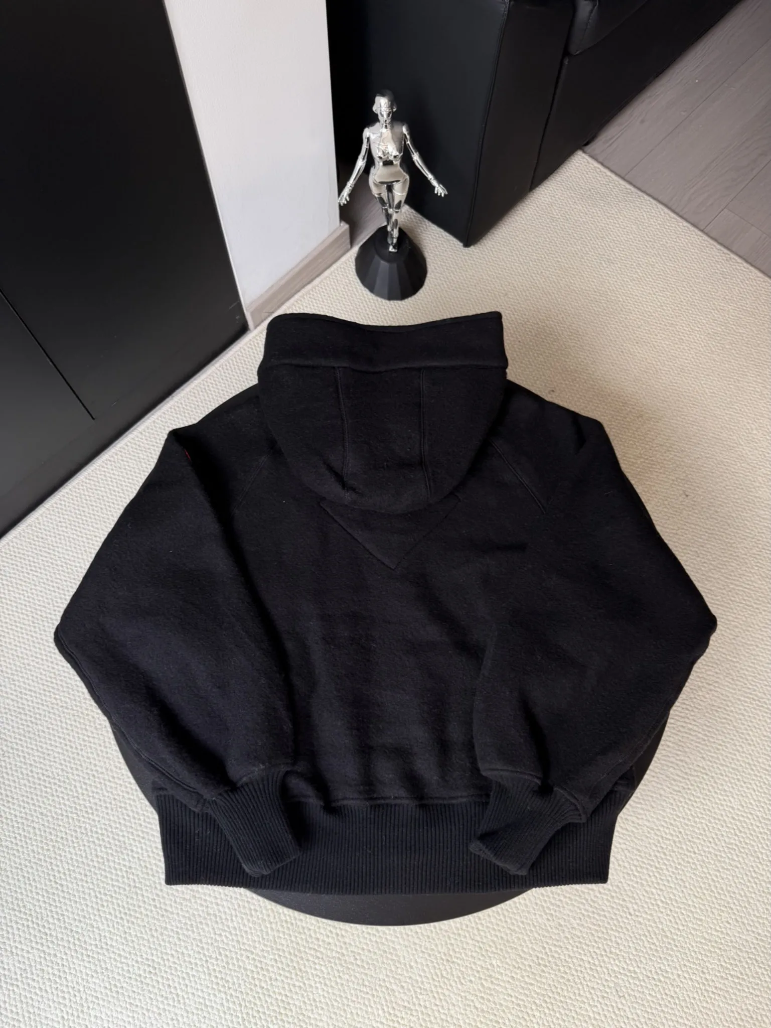 大鹅/Canada Goose抓绒羊毛饰章连帽夹克外套 面料选择: 以羊毛为主体，加入极少量氨纶和聚酯纤维混纺而成的羊毛抓绒面料。羊毛作为核心天然成分，提供无与伦比的温度调节、抑菌防臭和亲肤感。少量氨纶的喂入赋予了面料一定的四向弹性，日常活动时毫无束缚感。作为抓绒结构的基础，聚酯纤维增强了面料的耐久性、抗皱性和快干性，它构成了抓绒的蓬松感，并提供锁住空气等功能。 细节1: 衣袖和下摆采用2乘2罗纹收口，其强大的弹性，可以紧密贴合不同粗细的手腕和腰部，形成一个有效的&lsquo;密封&rsquo;,防止冷风倒灌。在多次拉伸和使用后仍能保持原有形状，不易松垮变形。且罗纹袖口能传递一种设计感，强化视觉美观度。 细节2: 兜帽设计与松紧扣的搭配提升穿戴时的保暖度与防风性能。 辅料:定制弹性抽绳松紧扣定制拉链吊坠定制臂章 尺码：S M L 颜色：黑 灰 咖 米 粉