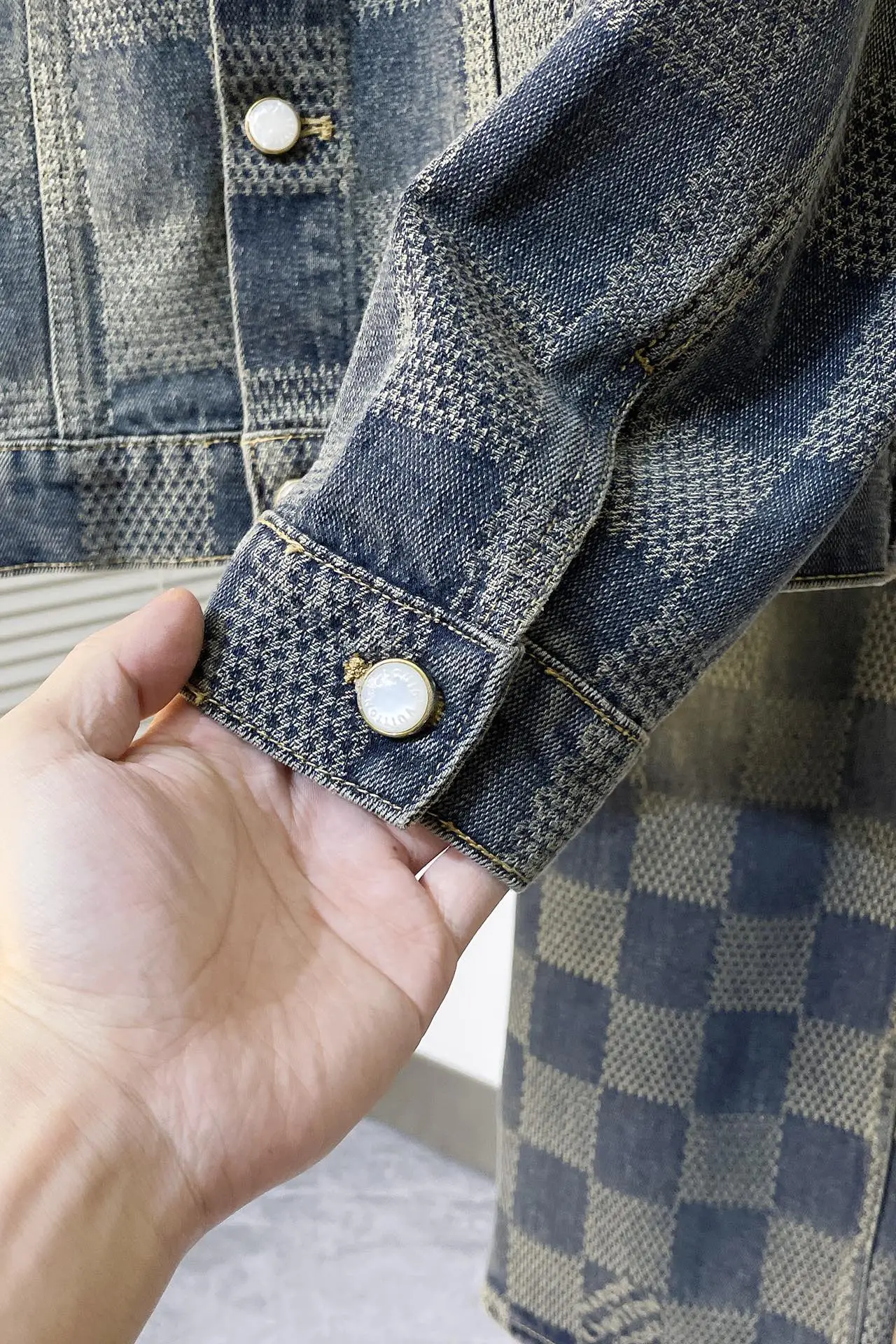 上衣 裤子 H244 LVV、25FW 棋盘格怀旧牛仔 原24,400购入,这款经典牛仔以标志性的3D Damier为特色,其纹理提花和“Marque L.Vuitton déposée”标志融为一体。这款最新版本采用水洗牛仔面料制成,面料采用定织粗斜纹布丹宁牛仔布,定染对色靛蓝效果做3D方格提花工艺。通过色织提花工艺,在织布过程中直接织入各种花纹和图案,使得牛仔布表面呈现出更加丰富的纹理和视觉效果。面料通过砂洗工艺和特殊的染色技术,洗涤后牛仔布的自然磨损和褪色效果,呈现出做旧的效果,使其看起来更加复古和具有历史感。对花对位贴袋设计,门槛采用新款珍珠扣做开合,珍珠面刻字清晰细腻、环保电镀,真皮吊钩搭配古铜链条,全套开模定制五金配件,三标辅料配备齐全。翻领设计和系扣袖口凝聚当季丹迪风采,修身直筒版型剪裁,与同款搭配相宜,独家首发出货。 尺码:S-XL 三标齐全 可拆卖