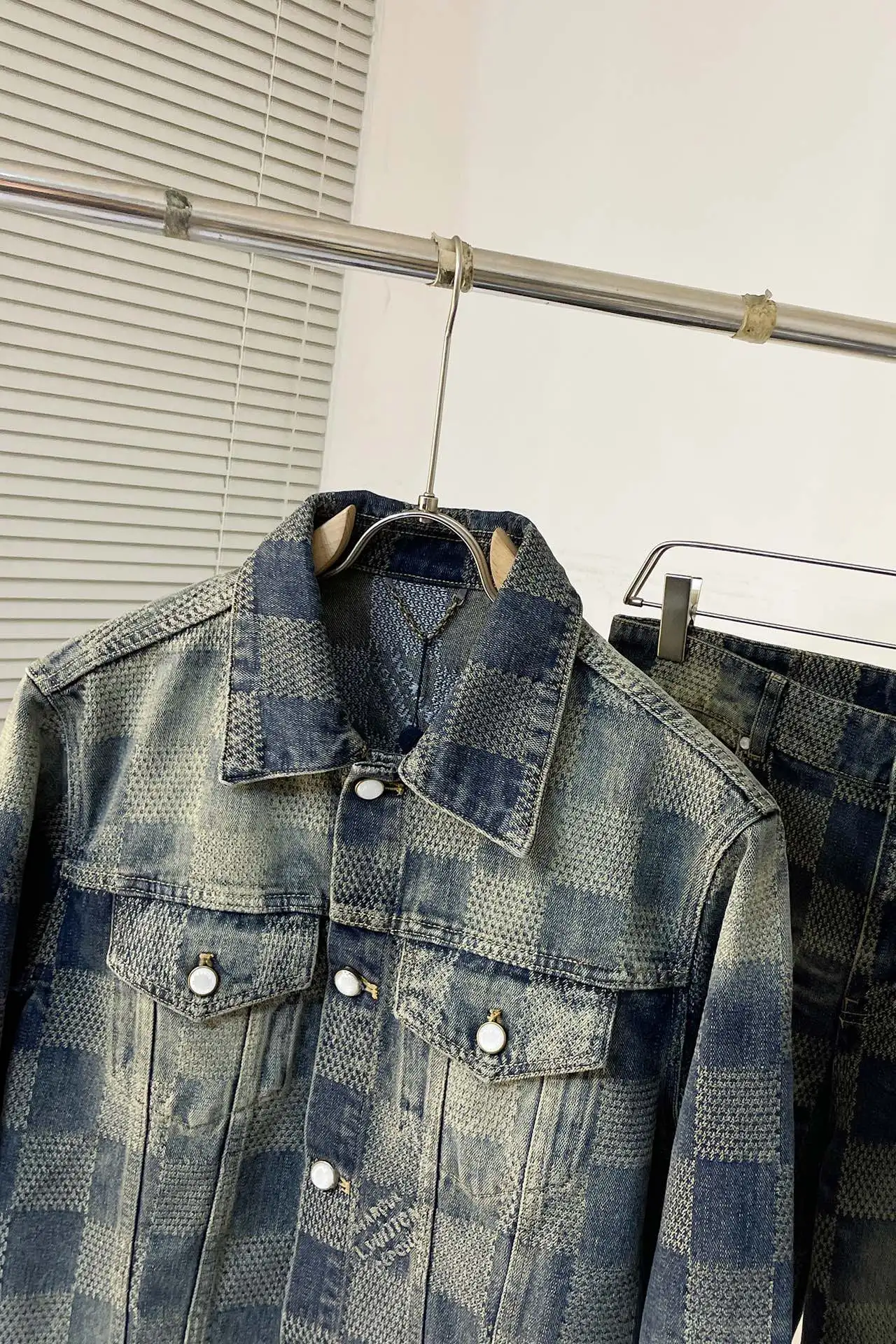 上衣 裤子 H244 LVV、25FW 棋盘格怀旧牛仔 原24,400购入,这款经典牛仔以标志性的3D Damier为特色,其纹理提花和“Marque L.Vuitton déposée”标志融为一体。这款最新版本采用水洗牛仔面料制成,面料采用定织粗斜纹布丹宁牛仔布,定染对色靛蓝效果做3D方格提花工艺。通过色织提花工艺,在织布过程中直接织入各种花纹和图案,使得牛仔布表面呈现出更加丰富的纹理和视觉效果。面料通过砂洗工艺和特殊的染色技术,洗涤后牛仔布的自然磨损和褪色效果,呈现出做旧的效果,使其看起来更加复古和具有历史感。对花对位贴袋设计,门槛采用新款珍珠扣做开合,珍珠面刻字清晰细腻、环保电镀,真皮吊钩搭配古铜链条,全套开模定制五金配件,三标辅料配备齐全。翻领设计和系扣袖口凝聚当季丹迪风采,修身直筒版型剪裁,与同款搭配相宜,独家首发出货。 尺码:S-XL 三标齐全 可拆卖