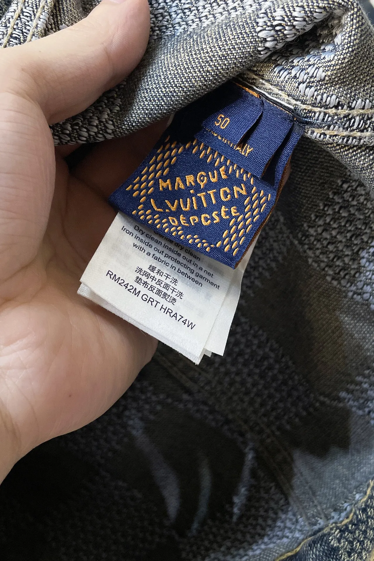 上衣 裤子 H244 LVV、25FW 棋盘格怀旧牛仔 原24,400购入,这款经典牛仔以标志性的3D Damier为特色,其纹理提花和“Marque L.Vuitton déposée”标志融为一体。这款最新版本采用水洗牛仔面料制成,面料采用定织粗斜纹布丹宁牛仔布,定染对色靛蓝效果做3D方格提花工艺。通过色织提花工艺,在织布过程中直接织入各种花纹和图案,使得牛仔布表面呈现出更加丰富的纹理和视觉效果。面料通过砂洗工艺和特殊的染色技术,洗涤后牛仔布的自然磨损和褪色效果,呈现出做旧的效果,使其看起来更加复古和具有历史感。对花对位贴袋设计,门槛采用新款珍珠扣做开合,珍珠面刻字清晰细腻、环保电镀,真皮吊钩搭配古铜链条,全套开模定制五金配件,三标辅料配备齐全。翻领设计和系扣袖口凝聚当季丹迪风采,修身直筒版型剪裁,与同款搭配相宜,独家首发出货。 尺码:S-XL 三标齐全 可拆卖