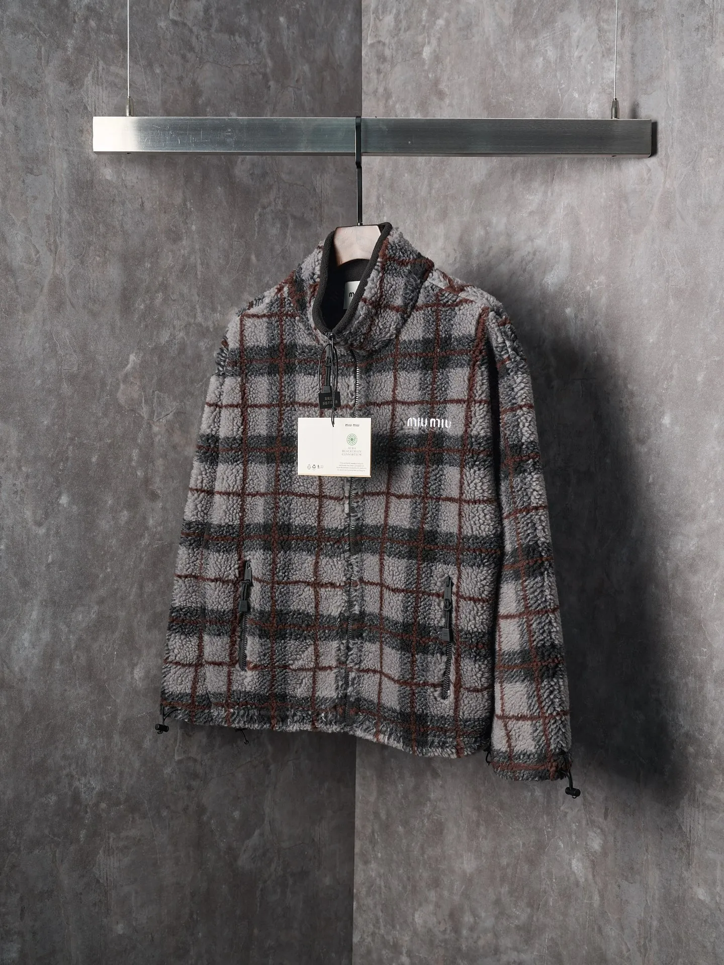 💰260【实物挂拍】MiuMiu/缪缪 羊羔绒格子刺绣拉链外套 【颜色】绿色 灰色 【现货】S M L XL 经典夹克在这款中被重新诠释，加入羊毛以增加厚度和柔软度。经典格纹图案汲取男装风格灵感，重新诠释运动女性气质的风格密码。 Oversize版型. 无衬里长袖立领.正面拉链开合 侧袋.双头钩针底边.刺绣徽标 采用80%羊毛，20%棉。该款面料原版定织定染，100%还原。内衬口袋布采用100%尼龙料， 后领位置搭配100%羊毛泰迪绒。 拉链采用尼龙与胶牙材料结合，拉牙采用欧款胶牙。下摆搭配原版刻字弹力扣。 刺绣采用3D立体刺绣工艺，刺绣logo饱满立体。呈现出高端视觉效果。