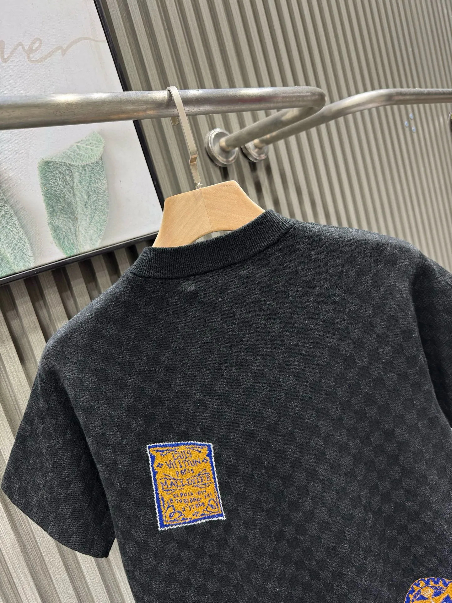 💰200🀄️ Louis Vuitton路易威登 LOUIS VUITTON 棋盘格标签针织短袖 采用定制棉质加光丝面料匠心制作 Damier提花嵌花织纹 德国进口挂毛机织片而成 织线原衣对色 环保固色定染 提花面料要求纱支精细衣身运用进口16针织令士提方格织法完美跟提花工艺每件耗时要150分钟 图案采取双面挂毛工艺 精细做工 肌理纹路清晰 极细织线由环保纤维打造 缝合采用的是16针盘 每个收口还要手工挑 缝线都要松紧一致要平顺 出品大身前后左右整齐对位理衣身面料具有软糯垂坠触感 面料舒适柔软 亲肤透气 富有弹性 全衣以棋盘格底纹 胸前品牌字母刺绣 配蓝色徽章设计感十足 和袖子均有品牌 细节做工精致 整体走线平直细腻 面料舒适柔软 颜色一致无色差 能与同款搭配营造时尚造型 三标齐全 男女同款