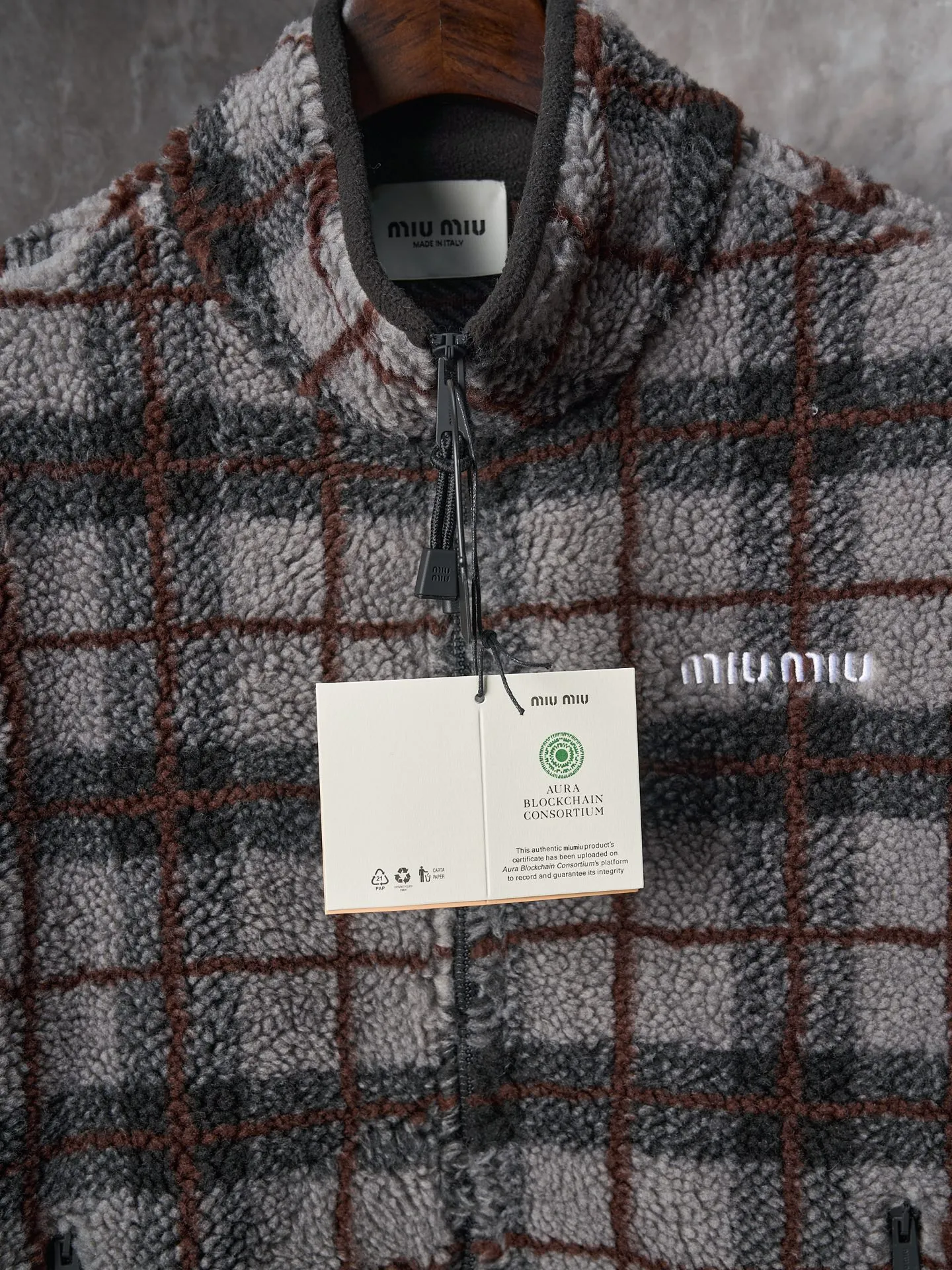 💰260【实物挂拍】MiuMiu/缪缪 羊羔绒格子刺绣拉链外套 【颜色】绿色 灰色 【现货】S M L XL 经典夹克在这款中被重新诠释，加入羊毛以增加厚度和柔软度。经典格纹图案汲取男装风格灵感，重新诠释运动女性气质的风格密码。 Oversize版型. 无衬里长袖立领.正面拉链开合 侧袋.双头钩针底边.刺绣徽标 采用80%羊毛，20%棉。该款面料原版定织定染，100%还原。内衬口袋布采用100%尼龙料， 后领位置搭配100%羊毛泰迪绒。 拉链采用尼龙与胶牙材料结合，拉牙采用欧款胶牙。下摆搭配原版刻字弹力扣。 刺绣采用3D立体刺绣工艺，刺绣logo饱满立体。呈现出高端视觉效果。