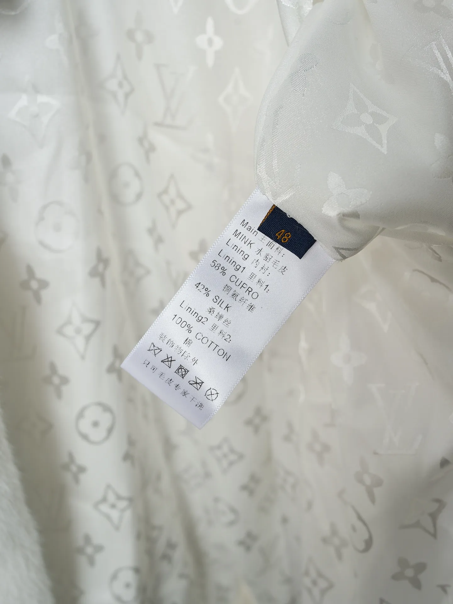 💰360【实物挂拍】LV/路易威登 Nigo联名系列水貂毛V领和服式皮草外套 【现货】46 48 50 52 面料选用北美优质水貂毛，经过手工分拣筛选，确保毛针长度、绒毛密度均匀一致，触感柔滑且光泽感强。剪裁采用无衬里极简结构，通过手工对缝拼接，避免车线痕迹破坏整体质感；领口做了宽幅翻折设计，边缘用隐形手工针脚收边，自然垂坠不生硬。袖口是同材质毛面翻边，内侧加了薄衬布定型，既保持蓬松感又不易变形；口袋为嵌式设计，开口边缘手工锁边，与衣身纹理无缝衔接。内里搭配品牌专属缎面衬里，标签通过定制挂链固定，细节处体现高定工艺标准。整体走线平直细腻，面料舒适柔软，颜色一致无色差 能与同款搭配营造时尚造型，驾驭各种场合，定制辅料，三标齐全，男女同款！