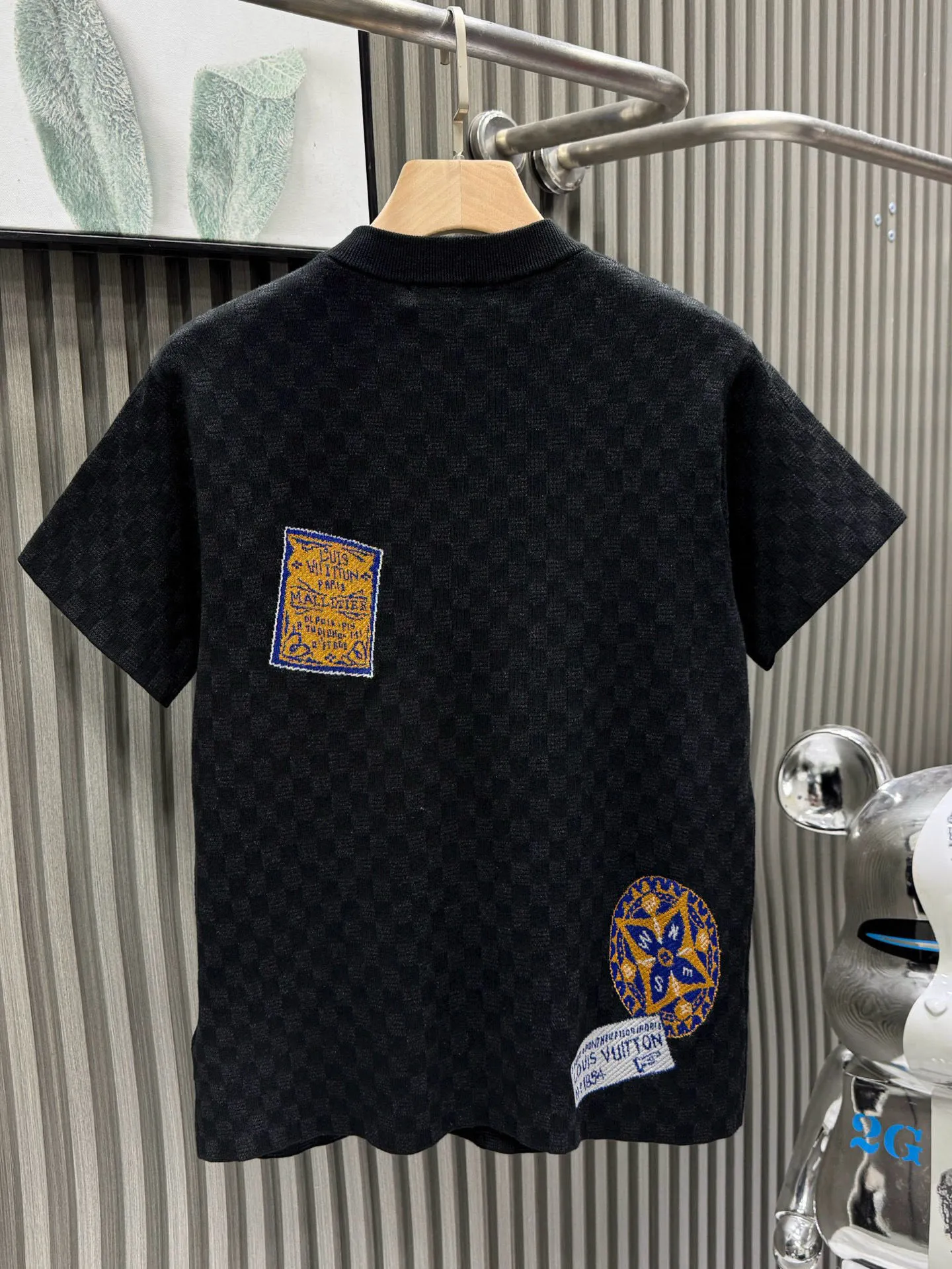 💰200🀄️ Louis Vuitton路易威登 LOUIS VUITTON 棋盘格标签针织短袖 采用定制棉质加光丝面料匠心制作 Damier提花嵌花织纹 德国进口挂毛机织片而成 织线原衣对色 环保固色定染 提花面料要求纱支精细衣身运用进口16针织令士提方格织法完美跟提花工艺每件耗时要150分钟 图案采取双面挂毛工艺 精细做工 肌理纹路清晰 极细织线由环保纤维打造 缝合采用的是16针盘 每个收口还要手工挑 缝线都要松紧一致要平顺 出品大身前后左右整齐对位理衣身面料具有软糯垂坠触感 面料舒适柔软 亲肤透气 富有弹性 全衣以棋盘格底纹 胸前品牌字母刺绣 配蓝色徽章设计感十足 和袖子均有品牌 细节做工精致 整体走线平直细腻 面料舒适柔软 颜色一致无色差 能与同款搭配营造时尚造型 三标齐全 男女同款