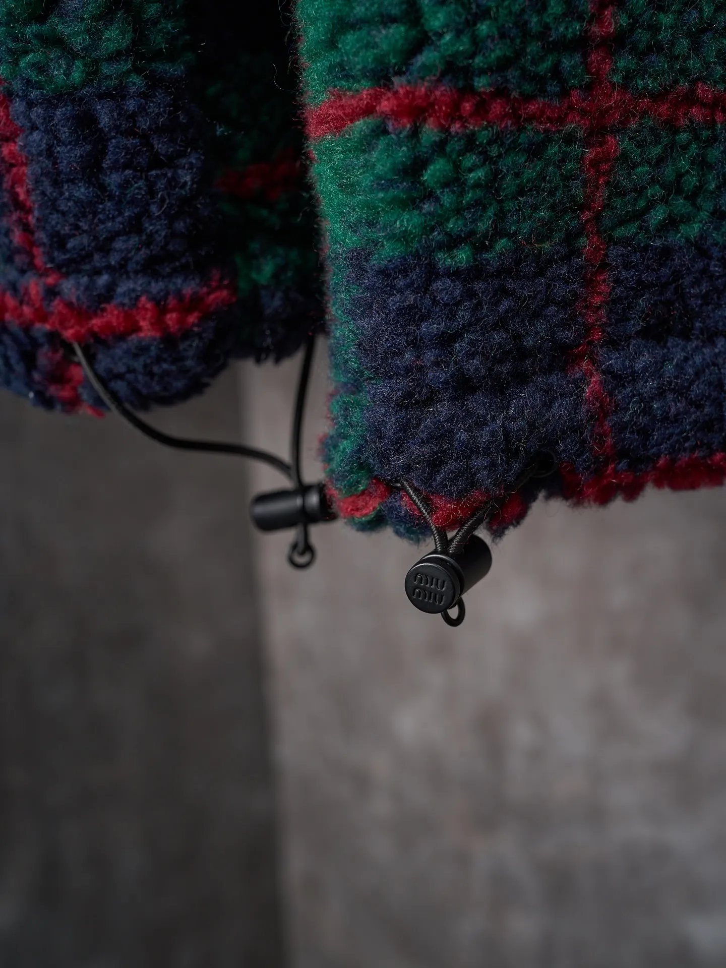 💰260【实物挂拍】MiuMiu/缪缪 羊羔绒格子刺绣拉链外套 【颜色】绿色 灰色 【现货】S M L XL 经典夹克在这款中被重新诠释，加入羊毛以增加厚度和柔软度。经典格纹图案汲取男装风格灵感，重新诠释运动女性气质的风格密码。 Oversize版型. 无衬里长袖立领.正面拉链开合 侧袋.双头钩针底边.刺绣徽标 采用80%羊毛，20%棉。该款面料原版定织定染，100%还原。内衬口袋布采用100%尼龙料， 后领位置搭配100%羊毛泰迪绒。 拉链采用尼龙与胶牙材料结合，拉牙采用欧款胶牙。下摆搭配原版刻字弹力扣。 刺绣采用3D立体刺绣工艺，刺绣logo饱满立体。呈现出高端视觉效果。