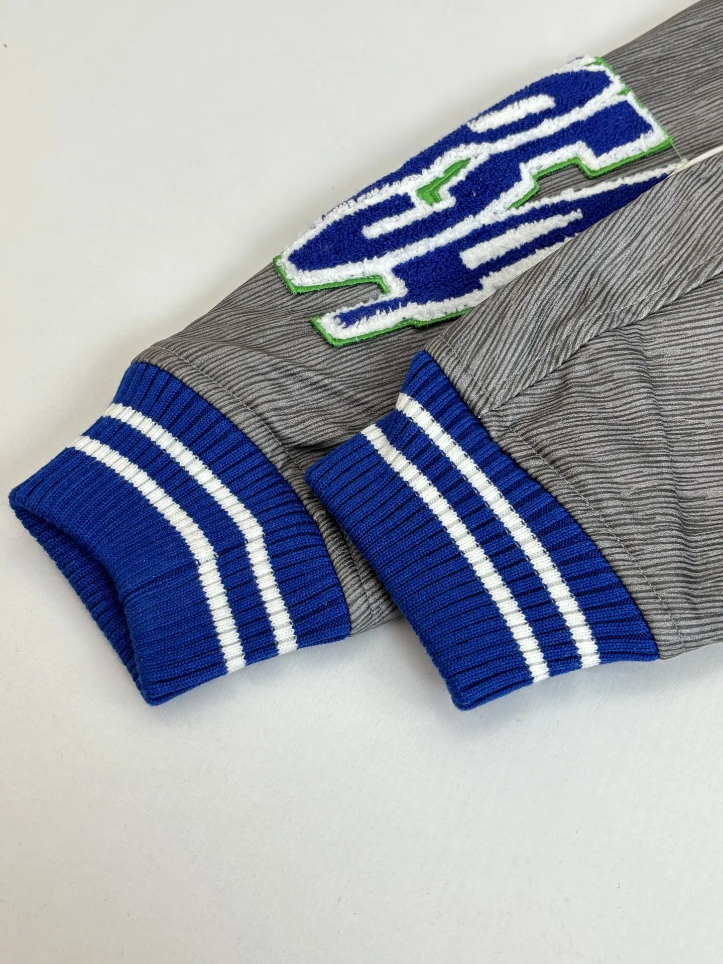 P410 1V/路易 FW23 毛巾绣花棒球服外套 面料成分有65%的羊毛，15%天然丝，10%的氨纶，10%绒混合定织而成，总的克重有900多克，还有最为关键的是色牢度，牢固不会褪色，袖子用的进口粒面皮质，加工定型，上色，水洗，纹路保留了原有的颗粒结构，厚实饱满圆润，刺绣使用进口毛巾绣机器，先把每个图案绣在毛毡上，在用红外线激光雕刻出来，再有缝纫机进行固定，这件衣服有多处贴标，一处平绣，后身的大图案是直接绣在上面的，这款衣服有4种不同工艺的绣花，螺纹采用全棉纱线定染定织而成，粗纱横机编织而成，不起球，棉质亲肤，立体感十足，定制辅料三标，洗涤建议首选干洗，次选手洗或者轻柔机洗，机洗请单独单件套洗衣袋轻柔机洗，不能烘干和热水洗涤，不能长时间浸泡暴晒，正确的洗涤方式可使衣服使用寿命延长 Size：S/M/L/XL