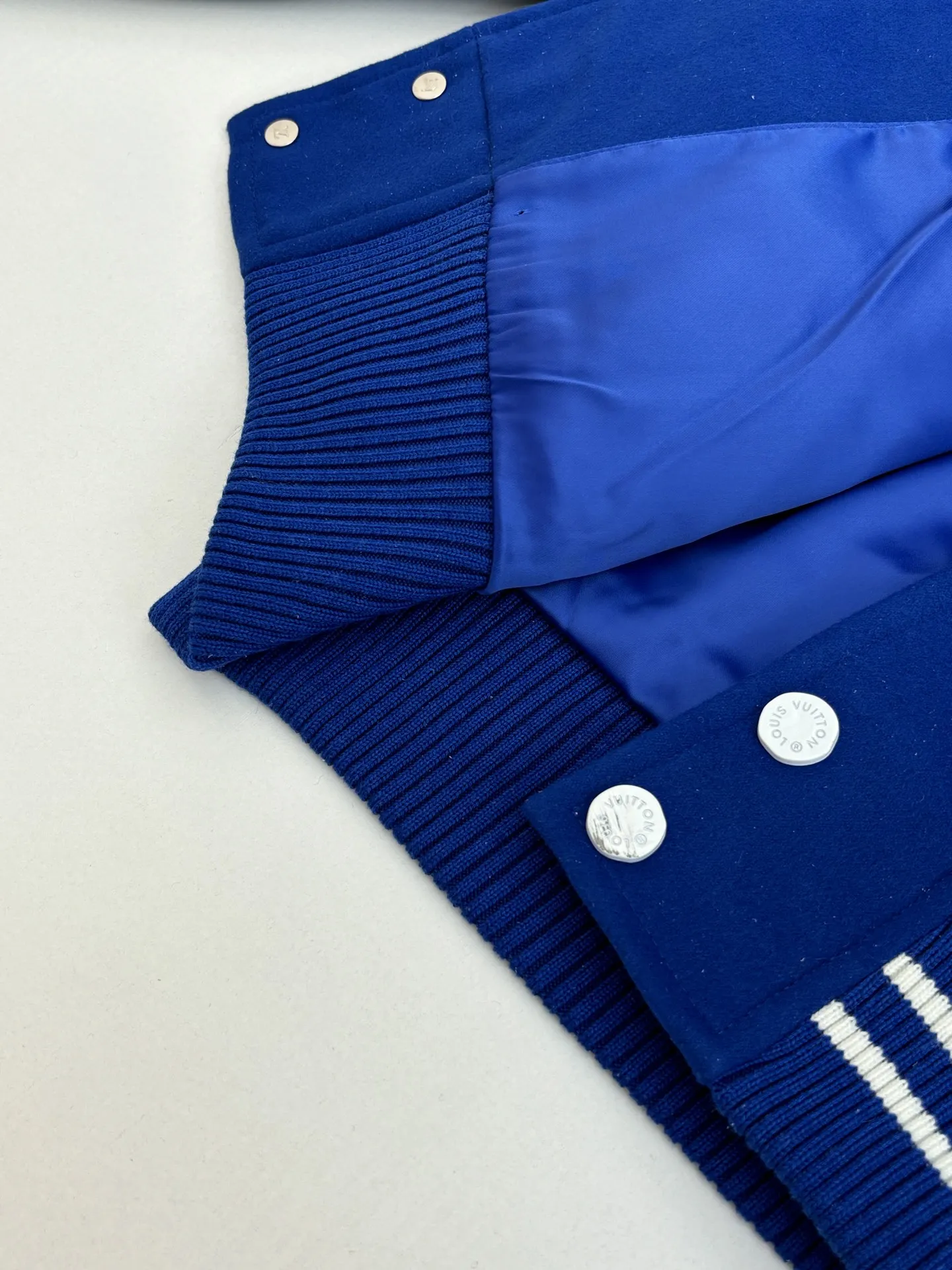 P410 1V/路易 FW23 毛巾绣花棒球服外套 面料成分有65%的羊毛，15%天然丝，10%的氨纶，10%绒混合定织而成，总的克重有900多克，还有最为关键的是色牢度，牢固不会褪色，袖子用的进口粒面皮质，加工定型，上色，水洗，纹路保留了原有的颗粒结构，厚实饱满圆润，刺绣使用进口毛巾绣机器，先把每个图案绣在毛毡上，在用红外线激光雕刻出来，再有缝纫机进行固定，这件衣服有多处贴标，一处平绣，后身的大图案是直接绣在上面的，这款衣服有4种不同工艺的绣花，螺纹采用全棉纱线定染定织而成，粗纱横机编织而成，不起球，棉质亲肤，立体感十足，定制辅料三标，洗涤建议首选干洗，次选手洗或者轻柔机洗，机洗请单独单件套洗衣袋轻柔机洗，不能烘干和热水洗涤，不能长时间浸泡暴晒，正确的洗涤方式可使衣服使用寿命延长 Size：S/M/L/XL