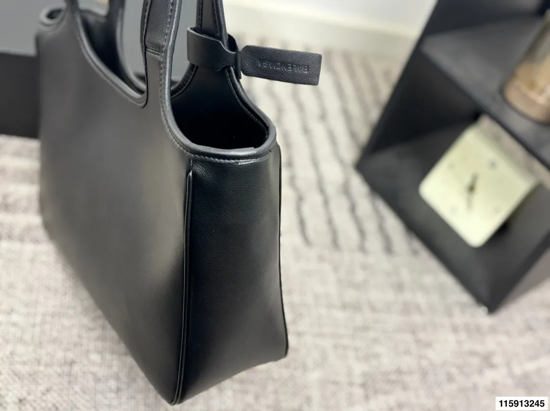 p145 配盒子 Balenciaga 巴黎世家 托特包 这款白色托特包采用柔软皮革,表面细腻有质感,设计极简,线条流畅,低调又高级。容量大,通勤或短途出行都很实用,手提肩背都方便。黑色百搭,轻松融入各种穿搭,简约风格爱好者必入!日常通勤、休闲场合都能hold住,实用又提升造型感山 尺寸36 24