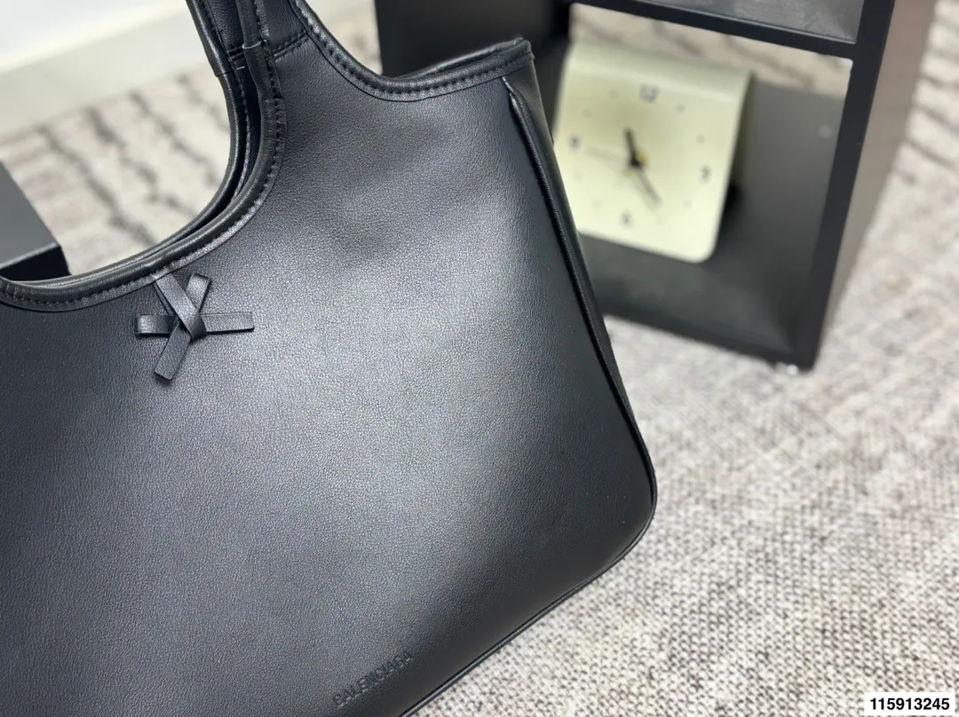 p145 配盒子 Balenciaga 巴黎世家 托特包 这款白色托特包采用柔软皮革，表面细腻有质感，设计极简，线条流畅，低调又高级。容量大，通勤或短途出行都很实用，手提肩背都方便。黑色百搭，轻松融入各种穿搭，简约风格爱好者必入！日常通勤、休闲场合都能hold住，实用又提升造型感山 尺寸36 24