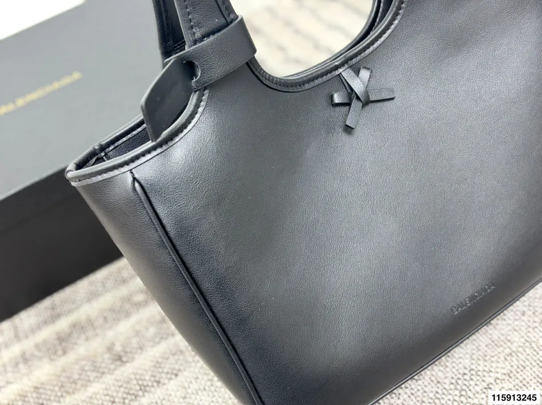 p145 配盒子 Balenciaga 巴黎世家 托特包 这款白色托特包采用柔软皮革，表面细腻有质感，设计极简，线条流畅，低调又高级。容量大，通勤或短途出行都很实用，手提肩背都方便。黑色百搭，轻松融入各种穿搭，简约风格爱好者必入！日常通勤、休闲场合都能hold住，实用又提升造型感山 尺寸36 24