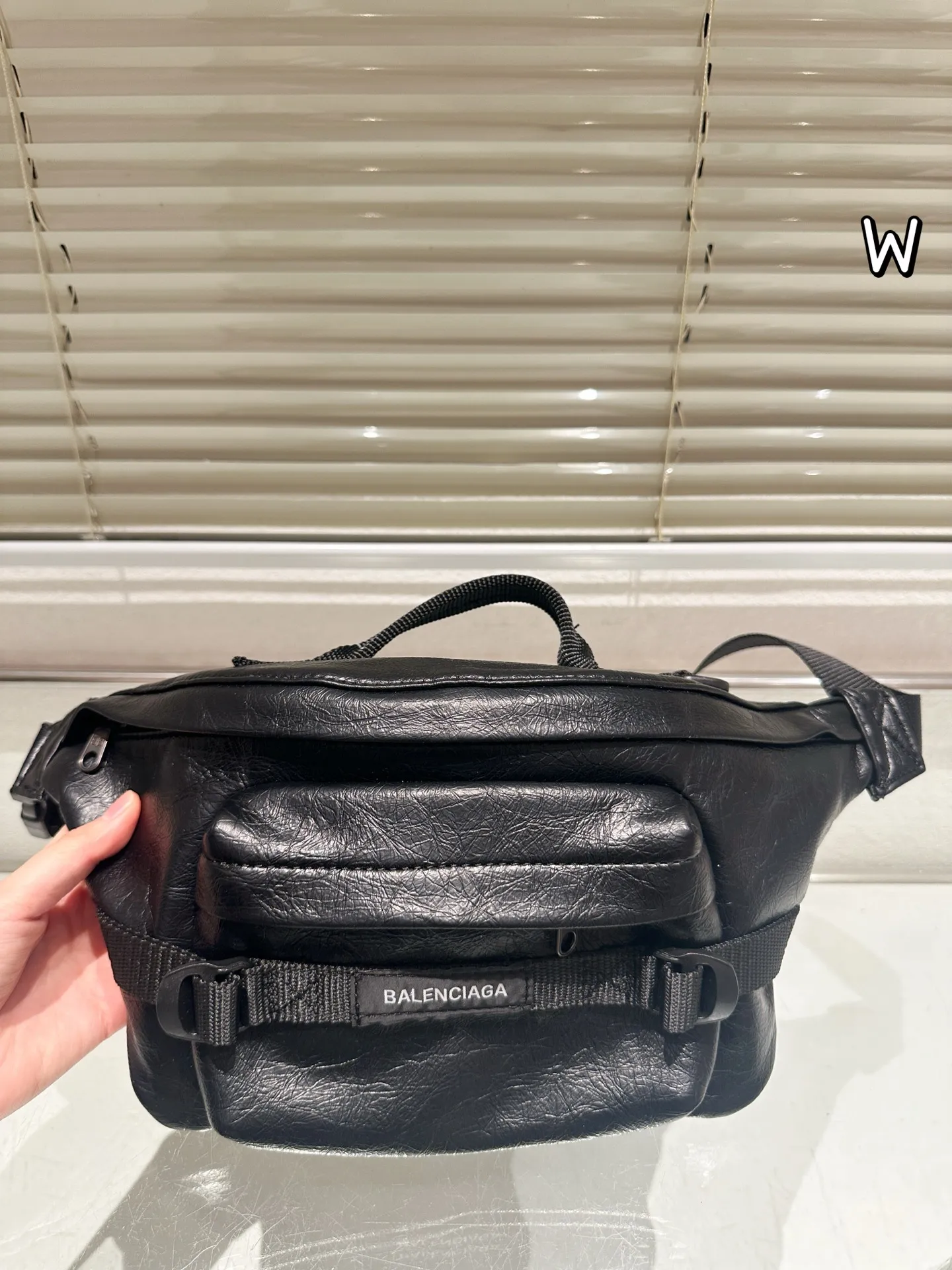 P140 巴黎世家 ARMY 系列腰包 •巴黎世家ARMY系列腰包,黑色小羊皮材质,手感细腻又耐用,机能风设计超有型!拉链+多口袋,收纳超方便,通勤、户外都能用林。肩带可调节, 腰包斜挎随心切换,百搭又实用。ARMY系列硬朗风格,潮流爱好者必入,搭配简约或机能风穿搭都很出彩 26x21x9cm约 26x21x9cm,