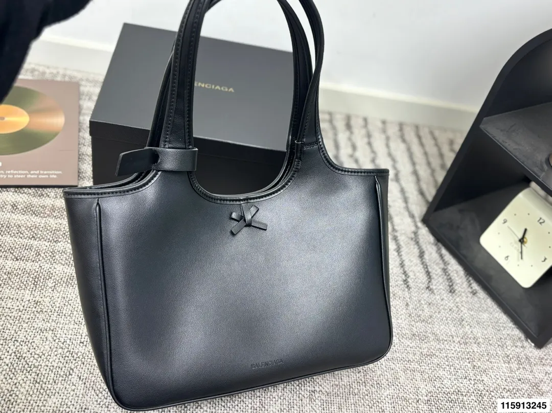 p145 配盒子 Balenciaga 巴黎世家 托特包 这款白色托特包采用柔软皮革，表面细腻有质感，设计极简，线条流畅，低调又高级。容量大，通勤或短途出行都很实用，手提肩背都方便。黑色百搭，轻松融入各种穿搭，简约风格爱好者必入！日常通勤、休闲场合都能hold住，实用又提升造型感山 尺寸36 24
