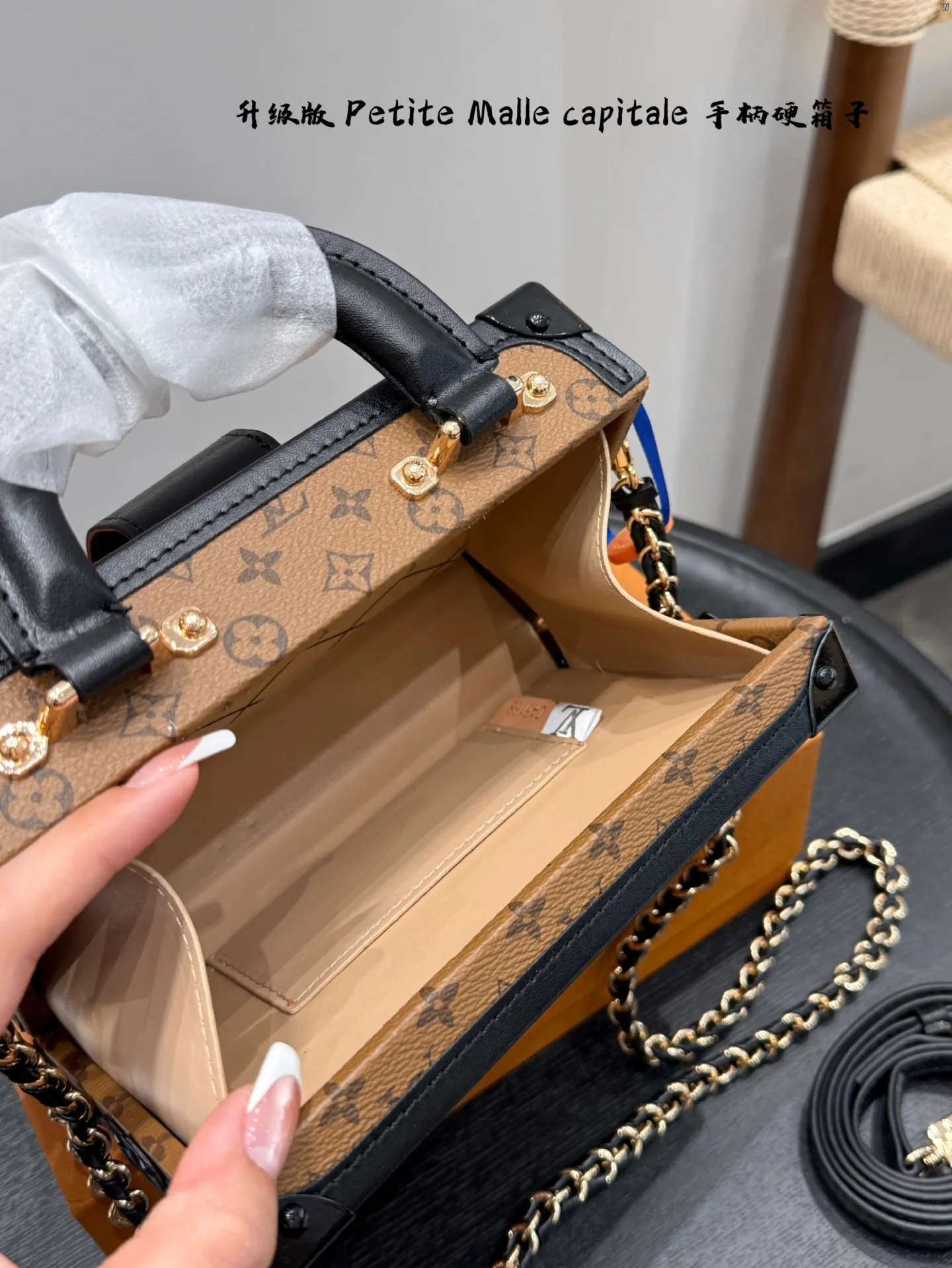 p185 礼盒包装 升级版！ size：19*12cm Lv 秀款Petite Malle capitale手提手柄盒子新款 手提硬箱 跟以往的小箱子设计外形一样，新款只是增加手提把手， 缓缓流露复古气息。 既时尚又实用，它是一款多功能包，轻巧易用，允许多种携带方式：手拎、肩扛和斜挎。