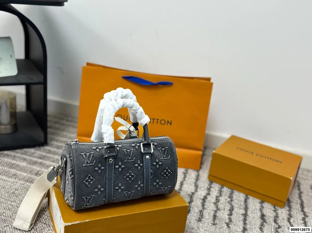 p185 配礼盒 LV Speedy 丹宁枕头包 这款Retiro手袋以标志性的LV老花面料制成，搭配奢华的变色牛皮饰边，经典永恒。优雅低调的外形设计和宽敞的包.尺寸：25*11*14cm