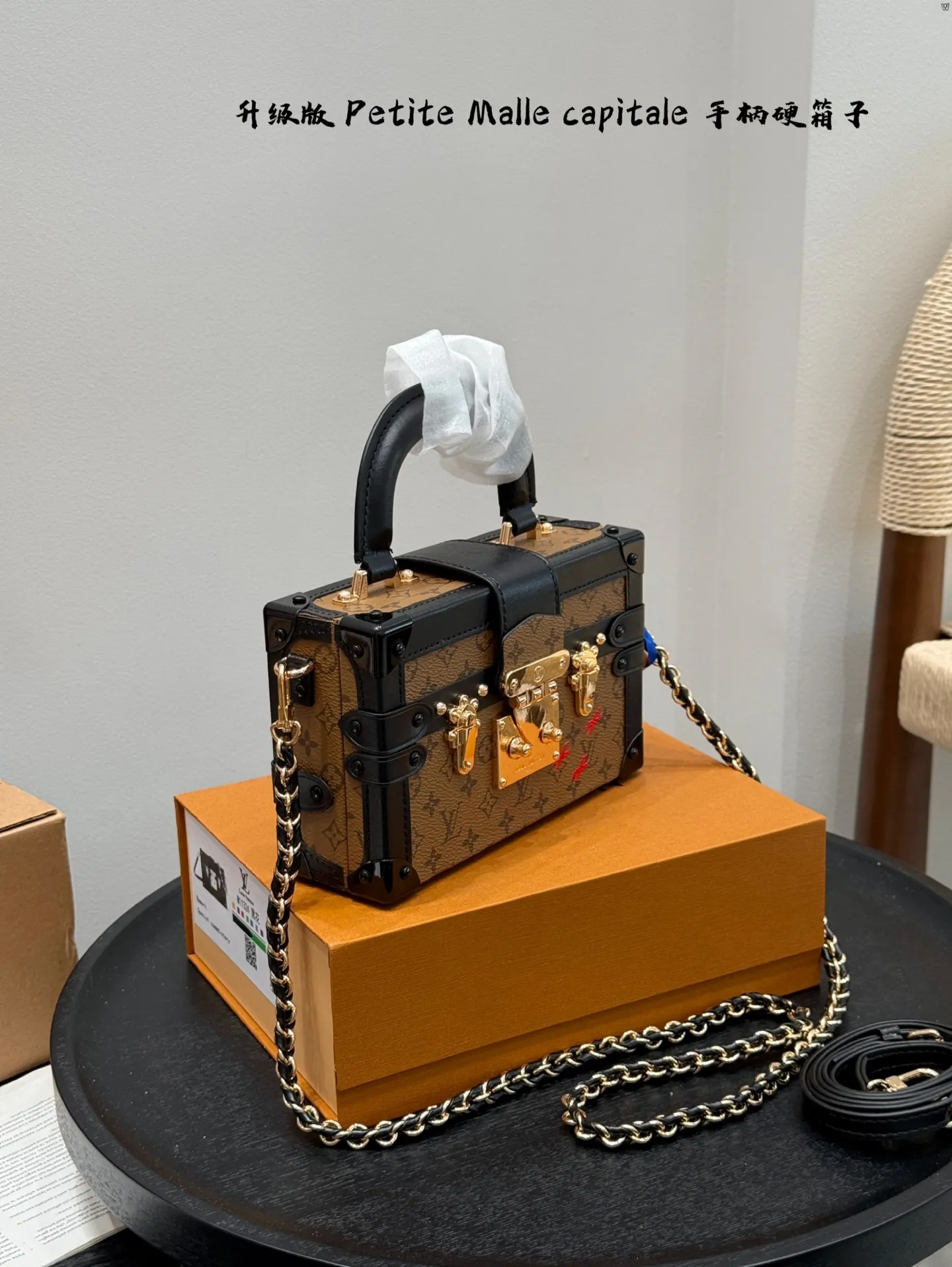 p185 礼盒包装 升级版! size:19*12cm Lv 秀款Petite Malle capitale手提手柄盒子新款 手提硬箱 跟以往的小箱子设计外形一样,新款只是增加手提把手, 缓缓流露复古气息。 既时尚又实用,它是一款多功能包,轻巧易用,允许多种携带方式:手拎、肩扛和斜挎。