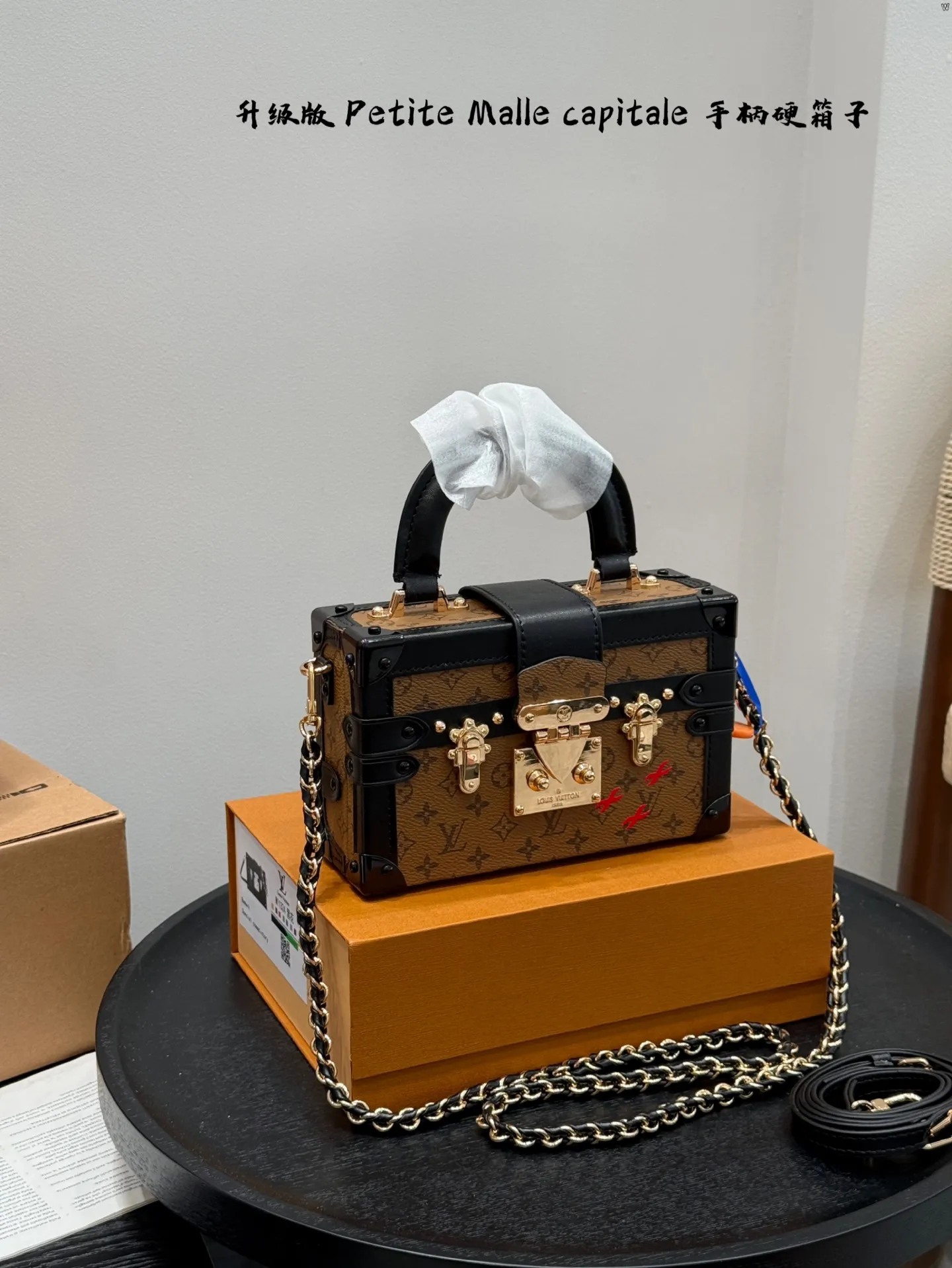 p185 礼盒包装 升级版! size:19*12cm Lv 秀款Petite Malle capitale手提手柄盒子新款 手提硬箱 跟以往的小箱子设计外形一样,新款只是增加手提把手, 缓缓流露复古气息。 既时尚又实用,它是一款多功能包,轻巧易用,允许多种携带方式:手拎、肩扛和斜挎。