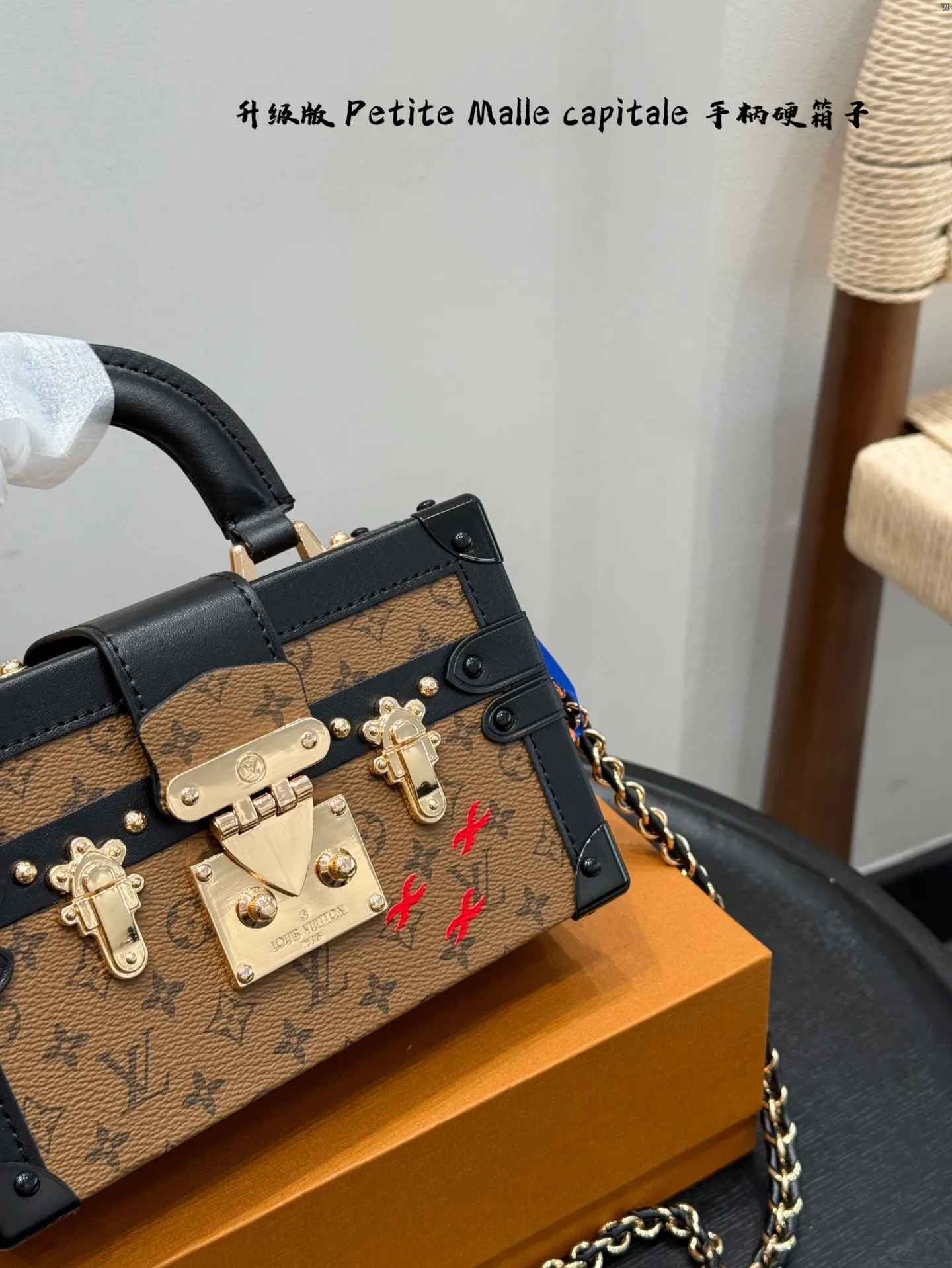 p185 礼盒包装 升级版! size:19*12cm Lv 秀款Petite Malle capitale手提手柄盒子新款 手提硬箱 跟以往的小箱子设计外形一样,新款只是增加手提把手, 缓缓流露复古气息。 既时尚又实用,它是一款多功能包,轻巧易用,允许多种携带方式:手拎、肩扛和斜挎。