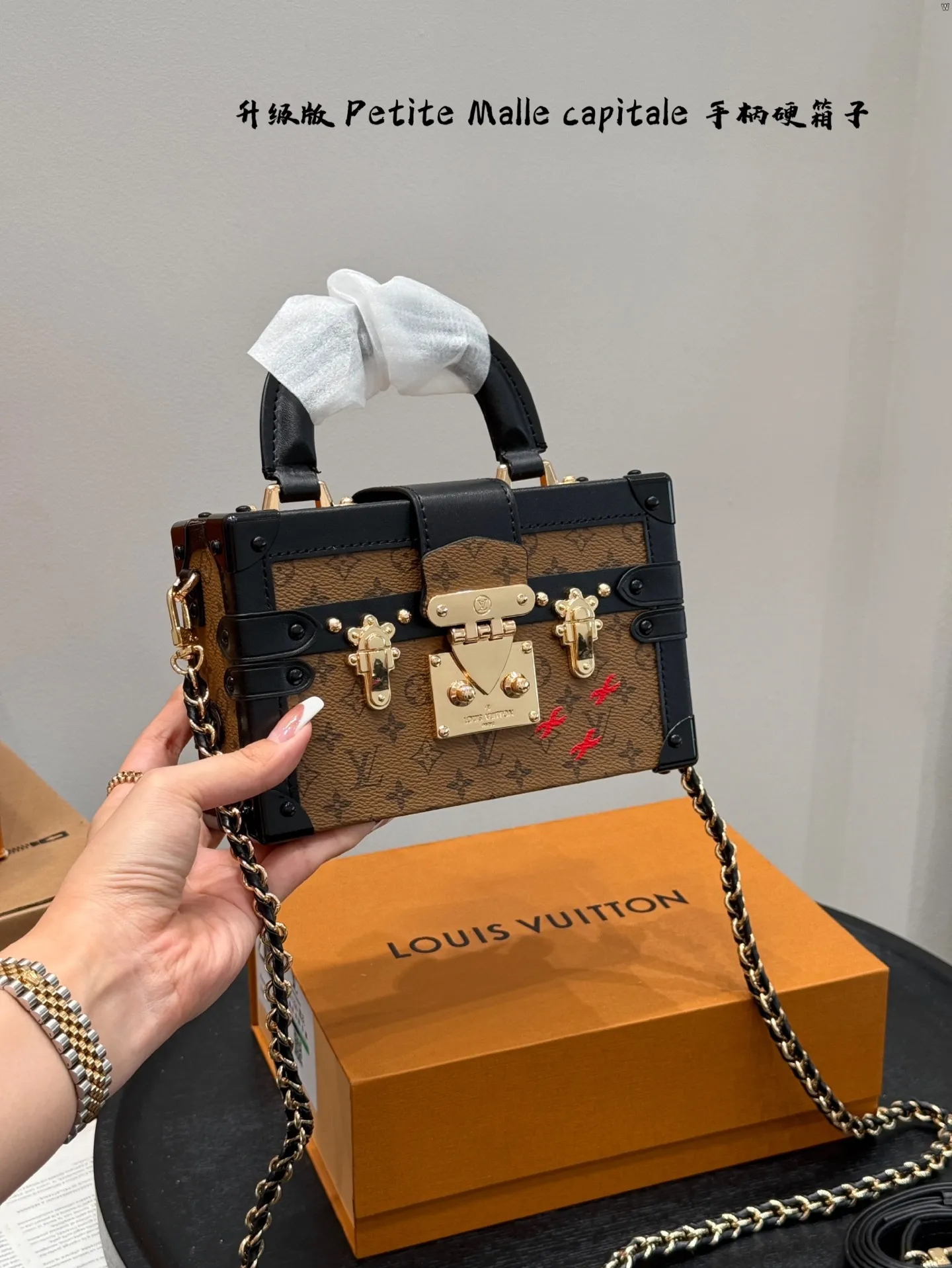 p185 礼盒包装 升级版! size:19*12cm Lv 秀款Petite Malle capitale手提手柄盒子新款 手提硬箱 跟以往的小箱子设计外形一样,新款只是增加手提把手, 缓缓流露复古气息。 既时尚又实用,它是一款多功能包,轻巧易用,允许多种携带方式:手拎、肩扛和斜挎。