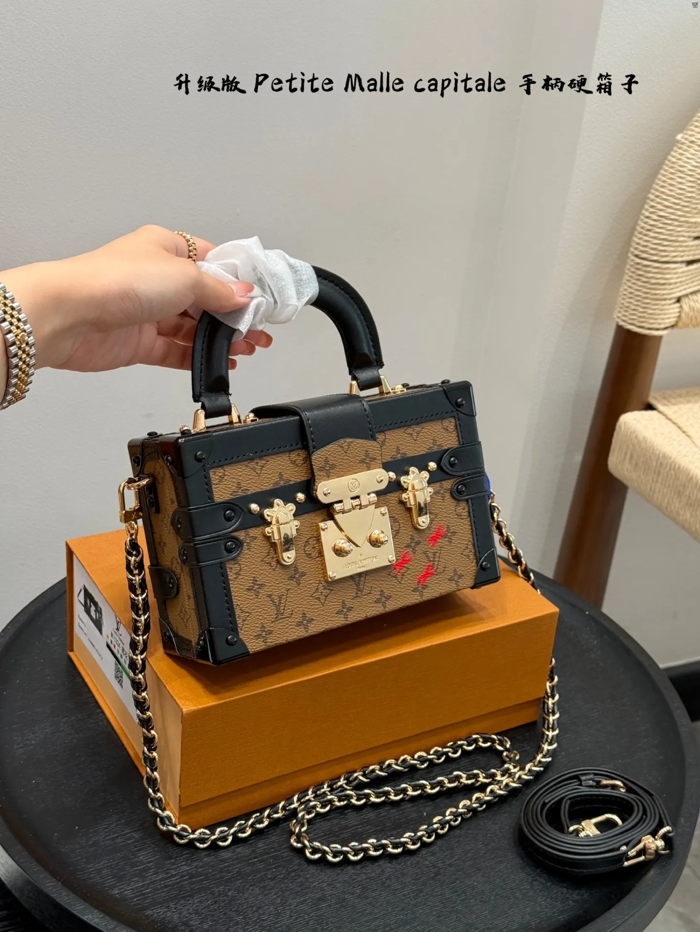 p185 礼盒包装 升级版! size:19*12cm Lv 秀款Petite Malle capitale手提手柄盒子新款 手提硬箱 跟以往的小箱子设计外形一样,新款只是增加手提把手, 缓缓流露复古气息。 既时尚又实用,它是一款多功能包,轻巧易用,允许多种携带方式:手拎、肩扛和斜挎。