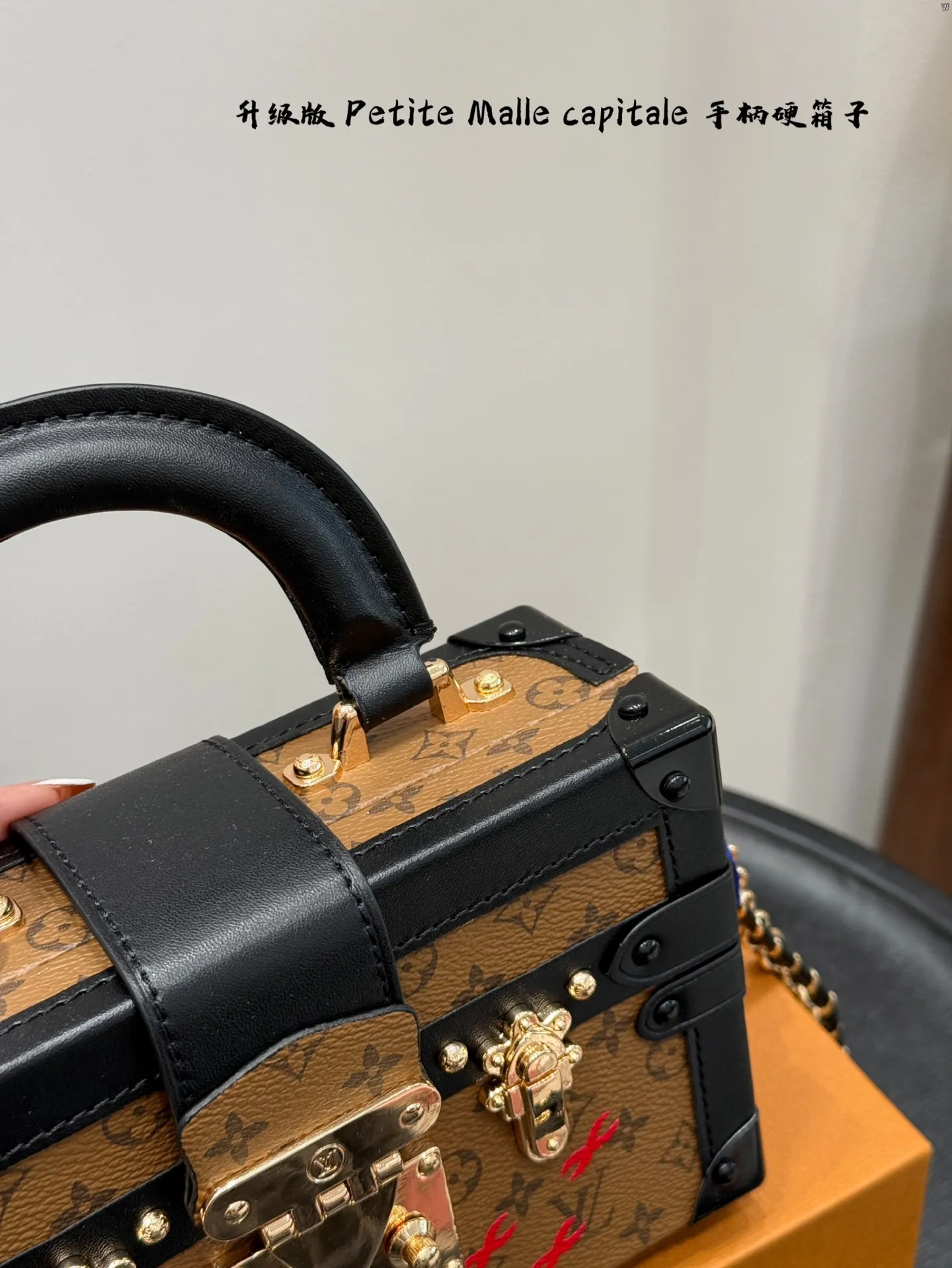 p185 礼盒包装 升级版! size:19*12cm Lv 秀款Petite Malle capitale手提手柄盒子新款 手提硬箱 跟以往的小箱子设计外形一样,新款只是增加手提把手, 缓缓流露复古气息。 既时尚又实用,它是一款多功能包,轻巧易用,允许多种携带方式:手拎、肩扛和斜挎。