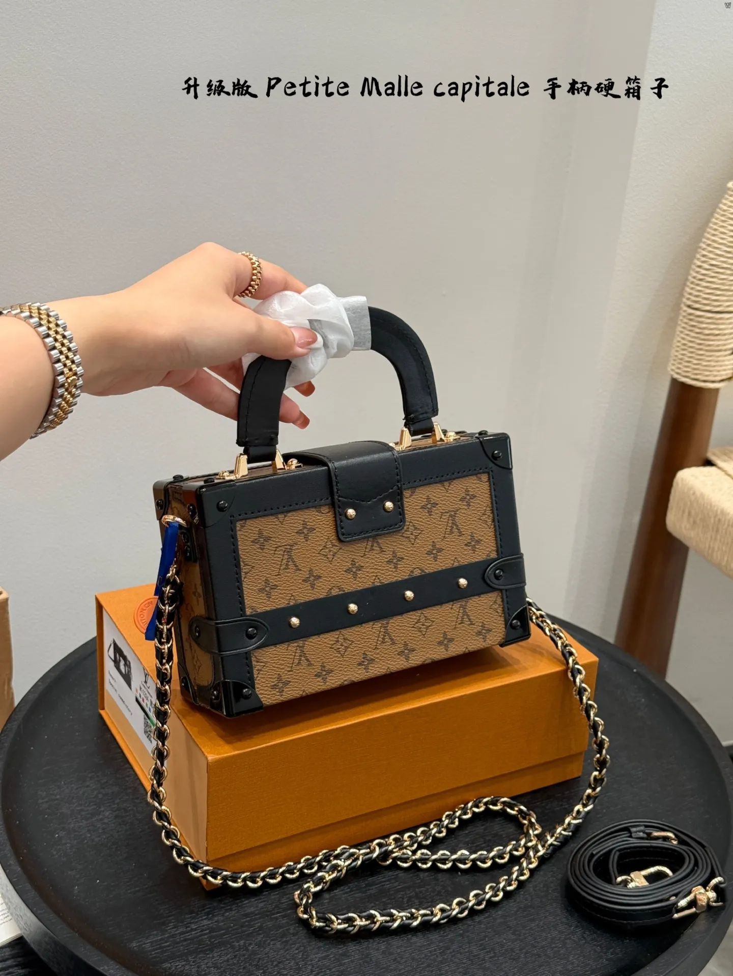 p185 礼盒包装 升级版！ size：19*12cm Lv 秀款Petite Malle capitale手提手柄盒子新款 手提硬箱 跟以往的小箱子设计外形一样，新款只是增加手提把手， 缓缓流露复古气息。 既时尚又实用，它是一款多功能包，轻巧易用，允许多种携带方式：手拎、肩扛和斜挎。