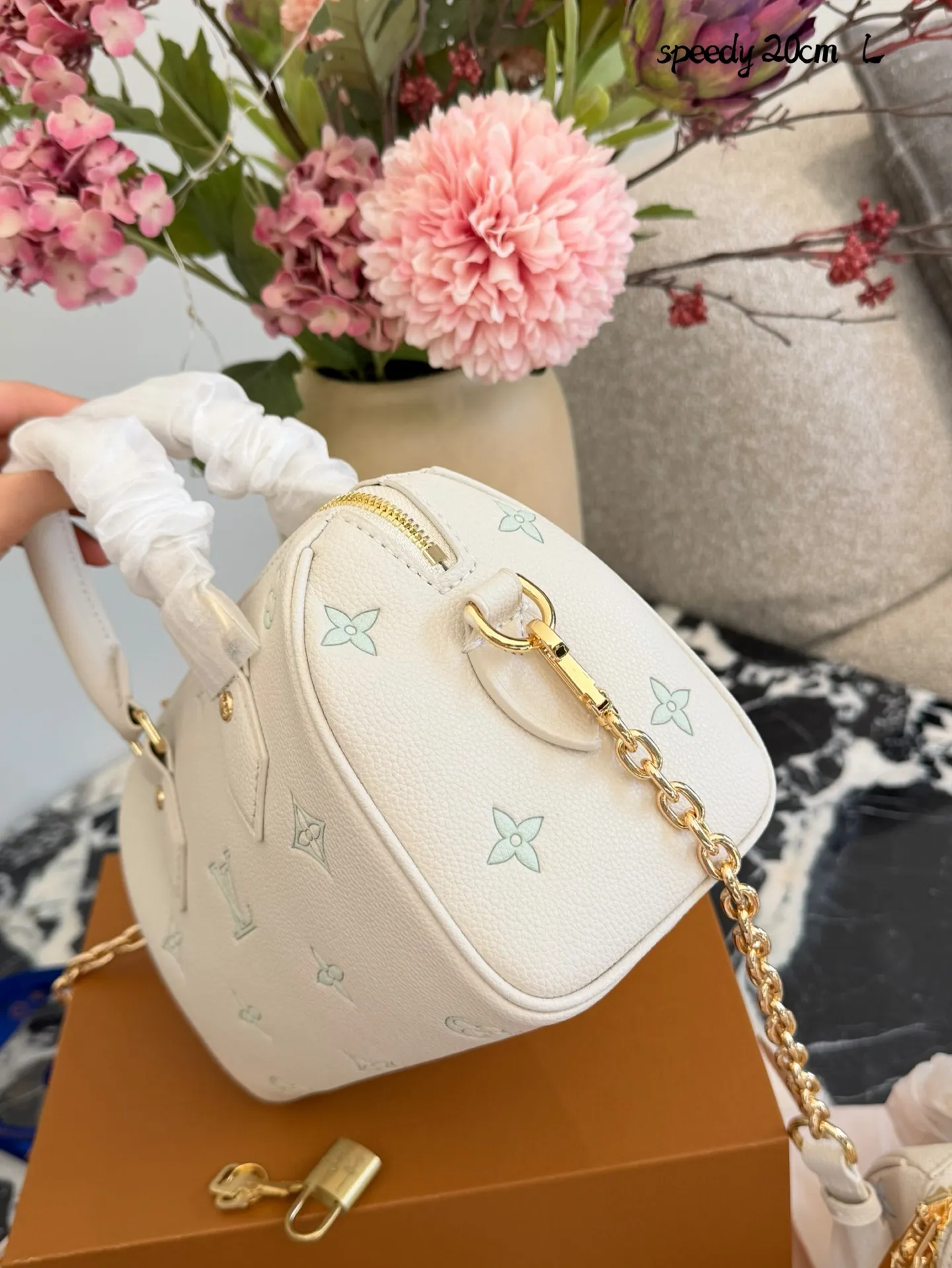 LV Speedy 20手袋p180 LV Speedy 20手袋，白色粒面牛皮+浅绿Monogram刺绣，清新优雅超有辨识度!金属锁扣+链条肩带，手提斜挎都OK，日常通勤、休闲出街都能轻松驾驭汁。内部空间合理，手机钱包都能装，实用又时髦，是LV经典系列的热门款，时尚感满分!