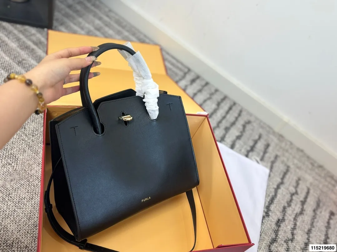 P180配折叠盒⚠️尺寸29.25 Furla Genesi托特包 选用优质牛皮，表面光滑有型，立体剪裁让包内空问更宽敞。金色半圆扭扣＋压印Logo，细节满分！尺寸适中，通勤休闲都OK，手提斜挎随心切换。黑色百搭，四季都能用，简约大气，实用又有质感，是职场女生的理想选择