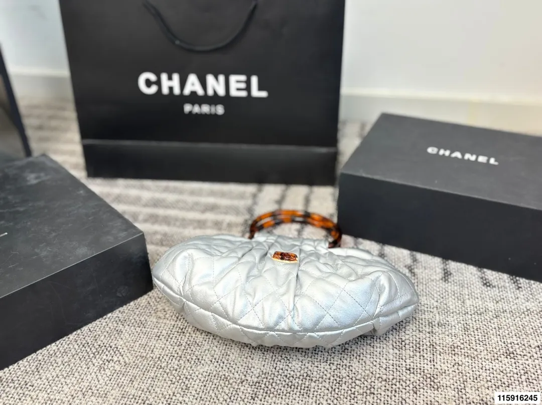 p145 配折叠盒 Chanel 26C玳瑁手柄福袋包 Chanel 26C早春系列福袋包,黑色麂皮+玳瑁色手柄,复古优雅感满满十。经典菱格纹缝线+双CLogo,细节超精致,手机小物轻松收纳,麂皮柔软,秋冬搭配超有氛围感 。玳瑁手柄光泽感强,手提或复古风都很出彩,实用又时髦,是热门单品! 尺寸 30.20