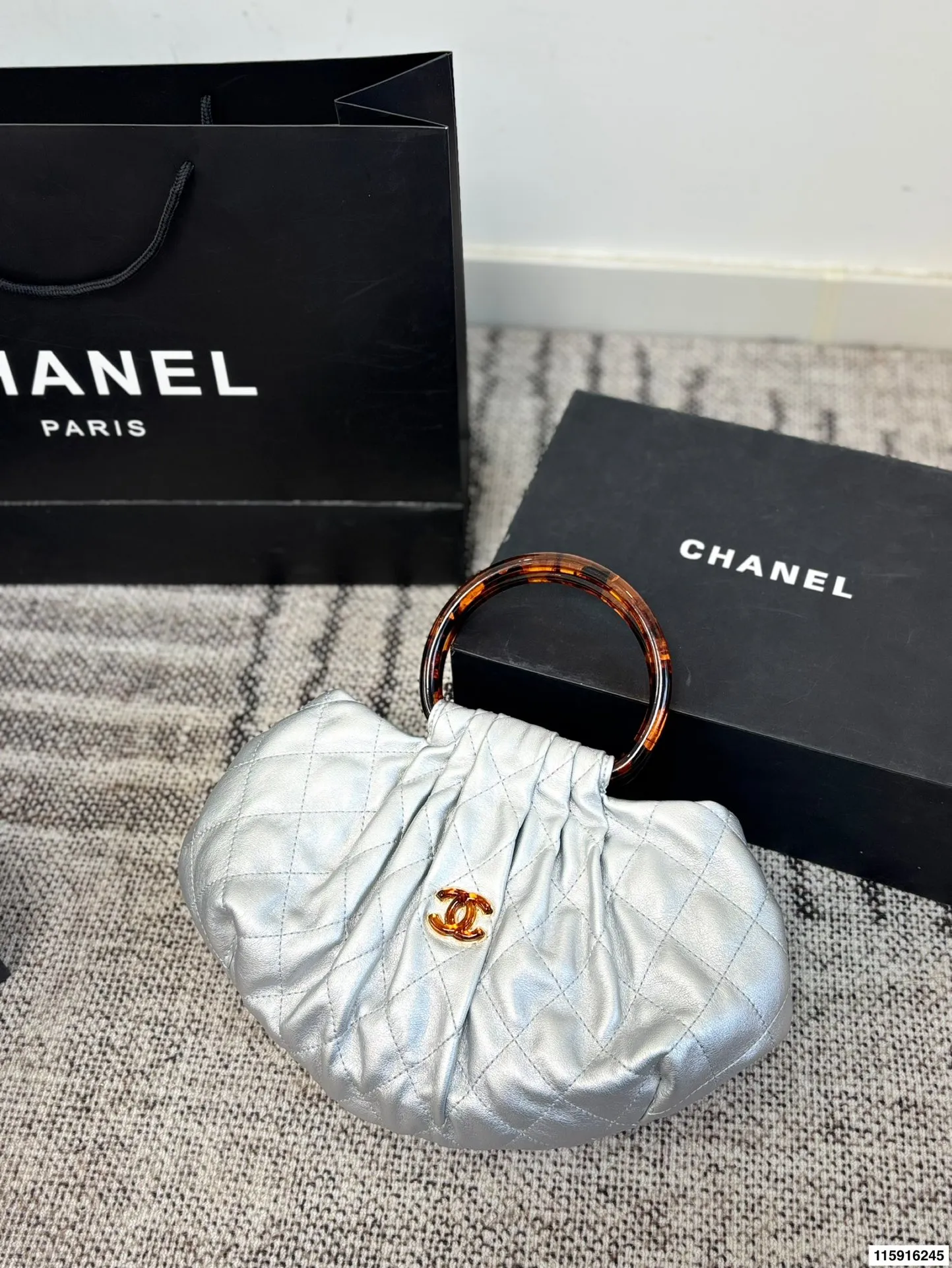 p145 配折叠盒 Chanel 26C玳瑁手柄福袋包 Chanel 26C早春系列福袋包,黑色麂皮+玳瑁色手柄,复古优雅感满满十。经典菱格纹缝线+双CLogo,细节超精致,手机小物轻松收纳,麂皮柔软,秋冬搭配超有氛围感 。玳瑁手柄光泽感强,手提或复古风都很出彩,实用又时髦,是热门单品! 尺寸 30.20