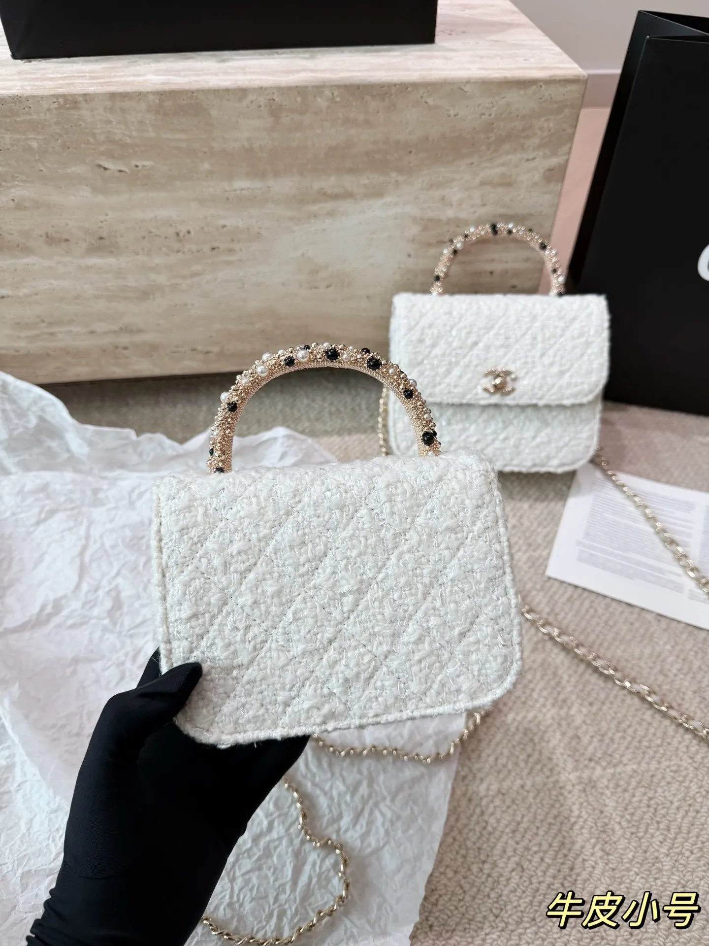 复刻版 P210 P200 chanel 香奈儿26C珍珠手柄手袋 香奈儿26C早春度假系列珍珠手柄手袋，白色粗花呢+经典菱格纹，金色双C标志超有辨识度艹。手柄点缀珍珠和黑色元素，精致又优雅，手提or晚宴包都很出彩！尺寸小巧，日常出行、搭配礼服都OK，实用又时髦，收藏控必入！ 尺寸 16 13cm 14 11cm