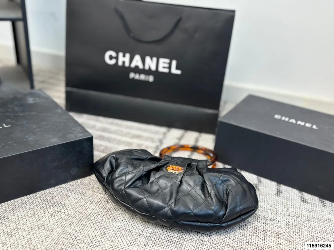 p145 配折叠盒 Chanel 26C玳瑁手柄福袋包 Chanel 26C早春系列福袋包，黑色麂皮+玳瑁色手柄，复古优雅感满满十。经典菱格纹缝线+双CLogo，细节超精致，手机小物轻松收纳，麂皮柔软，秋冬搭配超有氛围感 。玳瑁手柄光泽感强，手提或复古风都很出彩，实用又时髦，是热门单品！ 尺寸 30.20
