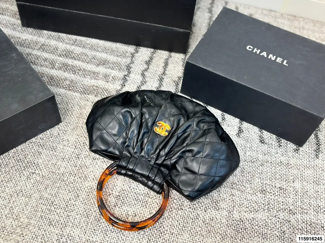 p145 配折叠盒 Chanel 26C玳瑁手柄福袋包 Chanel 26C早春系列福袋包，黑色麂皮+玳瑁色手柄，复古优雅感满满十。经典菱格纹缝线+双CLogo，细节超精致，手机小物轻松收纳，麂皮柔软，秋冬搭配超有氛围感 。玳瑁手柄光泽感强，手提或复古风都很出彩，实用又时髦，是热门单品！ 尺寸 30.20