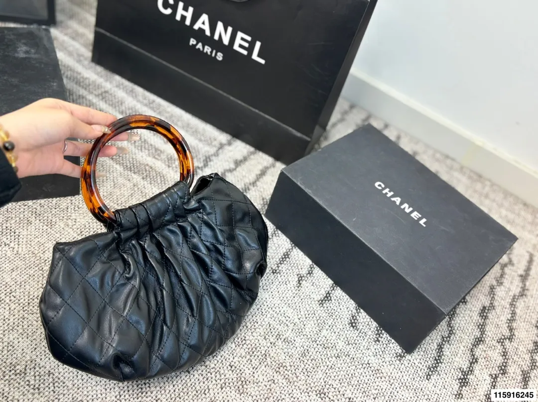 p145 配折叠盒 Chanel 26C玳瑁手柄福袋包 Chanel 26C早春系列福袋包,黑色麂皮+玳瑁色手柄,复古优雅感满满十。经典菱格纹缝线+双CLogo,细节超精致,手机小物轻松收纳,麂皮柔软,秋冬搭配超有氛围感 。玳瑁手柄光泽感强,手提或复古风都很出彩,实用又时髦,是热门单品! 尺寸 30.20