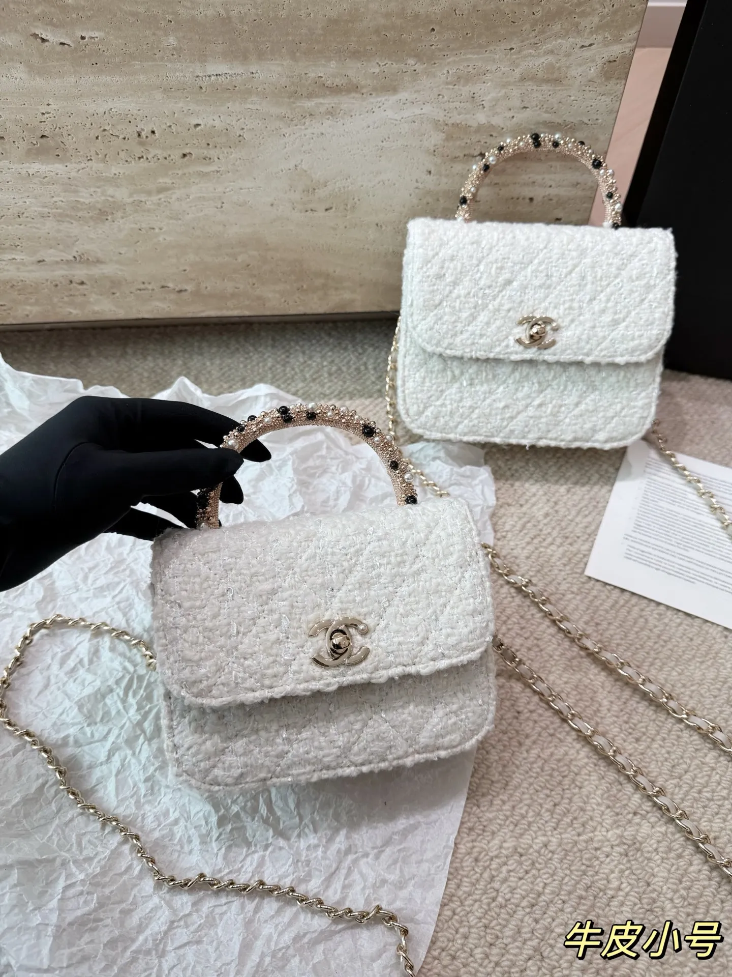 复刻版 P210 P200 chanel 香奈儿26C珍珠手柄手袋 香奈儿26C早春度假系列珍珠手柄手袋，白色粗花呢+经典菱格纹，金色双C标志超有辨识度艹。手柄点缀珍珠和黑色元素，精致又优雅，手提or晚宴包都很出彩！尺寸小巧，日常出行、搭配礼服都OK，实用又时髦，收藏控必入！ 尺寸 16 13cm 14 11cm