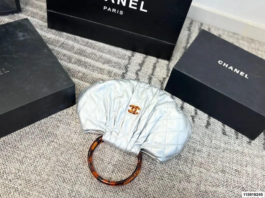 p145 配折叠盒 Chanel 26C玳瑁手柄福袋包 Chanel 26C早春系列福袋包,黑色麂皮+玳瑁色手柄,复古优雅感满满十。经典菱格纹缝线+双CLogo,细节超精致,手机小物轻松收纳,麂皮柔软,秋冬搭配超有氛围感 。玳瑁手柄光泽感强,手提或复古风都很出彩,实用又时髦,是热门单品! 尺寸 30.20