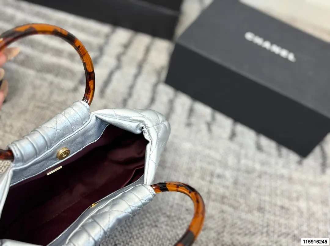 p145 配折叠盒 Chanel 26C玳瑁手柄福袋包 Chanel 26C早春系列福袋包,黑色麂皮+玳瑁色手柄,复古优雅感满满十。经典菱格纹缝线+双CLogo,细节超精致,手机小物轻松收纳,麂皮柔软,秋冬搭配超有氛围感 。玳瑁手柄光泽感强,手提或复古风都很出彩,实用又时髦,是热门单品! 尺寸 30.20