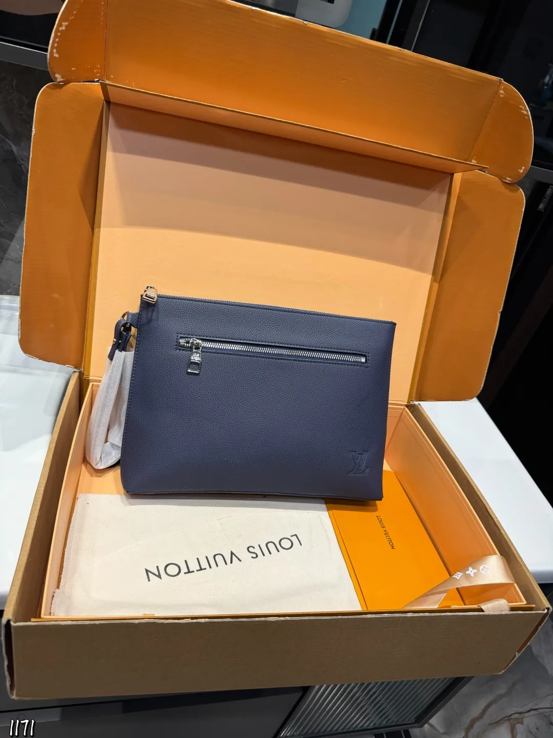 ❤️p110❤️ lv 本款 Takeoff 手拿包为蜡面牛皮革搭配深邃金属件和织物内衬，再令 LV 字母压纹栖身正面一隅，成就商务与休闲场合的精巧之选。充裕空间方便收纳平板电脑，可拆卸腕带实现灵活背携。 22 x 5x30cm