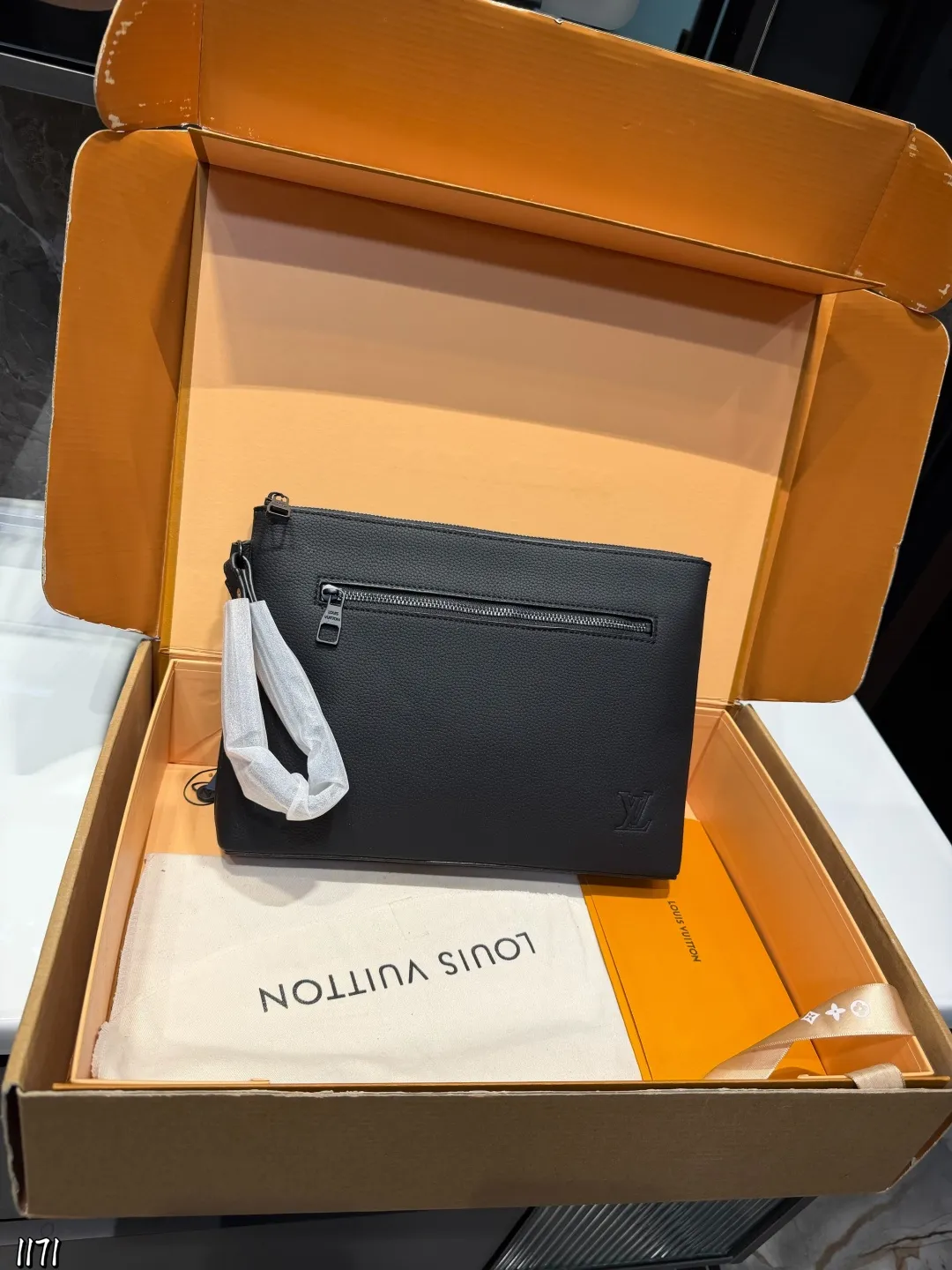 ❤️p110❤️ lv 本款 Takeoff 手拿包为蜡面牛皮革搭配深邃金属件和织物内衬，再令 LV 字母压纹栖身正面一隅，成就商务与休闲场合的精巧之选。充裕空间方便收纳平板电脑，可拆卸腕带实现灵活背携。 22 x 5x30cm