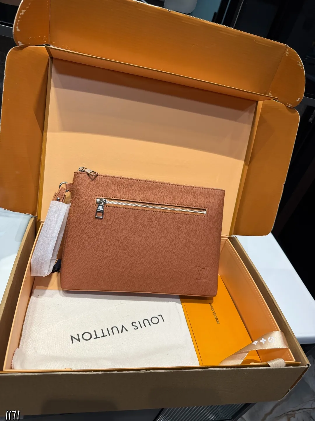 ❤️p110❤️ lv 本款 Takeoff 手拿包为蜡面牛皮革搭配深邃金属件和织物内衬，再令 LV 字母压纹栖身正面一隅，成就商务与休闲场合的精巧之选。充裕空间方便收纳平板电脑，可拆卸腕带实现灵活背携。 22 x 5x30cm