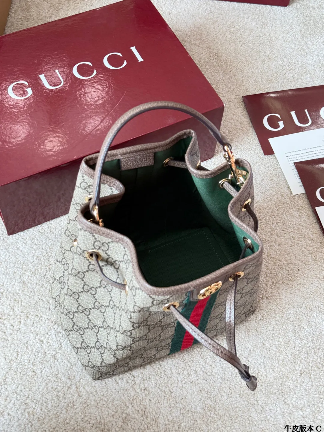 牛皮版本 p165 Gucci Ophidia 老花水桶包 Gucci Ophidia系列老花水桶包,采用米色/乌木色GGSupreme涂层帆布,搭配棕色皮革滚边和黄铜金属配件,复古又时髦!正面双G金属Logo+红绿织带,品牌辨识度超高。尺寸约20x22×14cm,抽绳开合,内部有开放式口袋和手机袋,日常通勤、休闲出行都很实用。肩带可调节,手拎、单肩、斜挎、双肩多种背法,百搭灵活,是Gucci经典热门款!