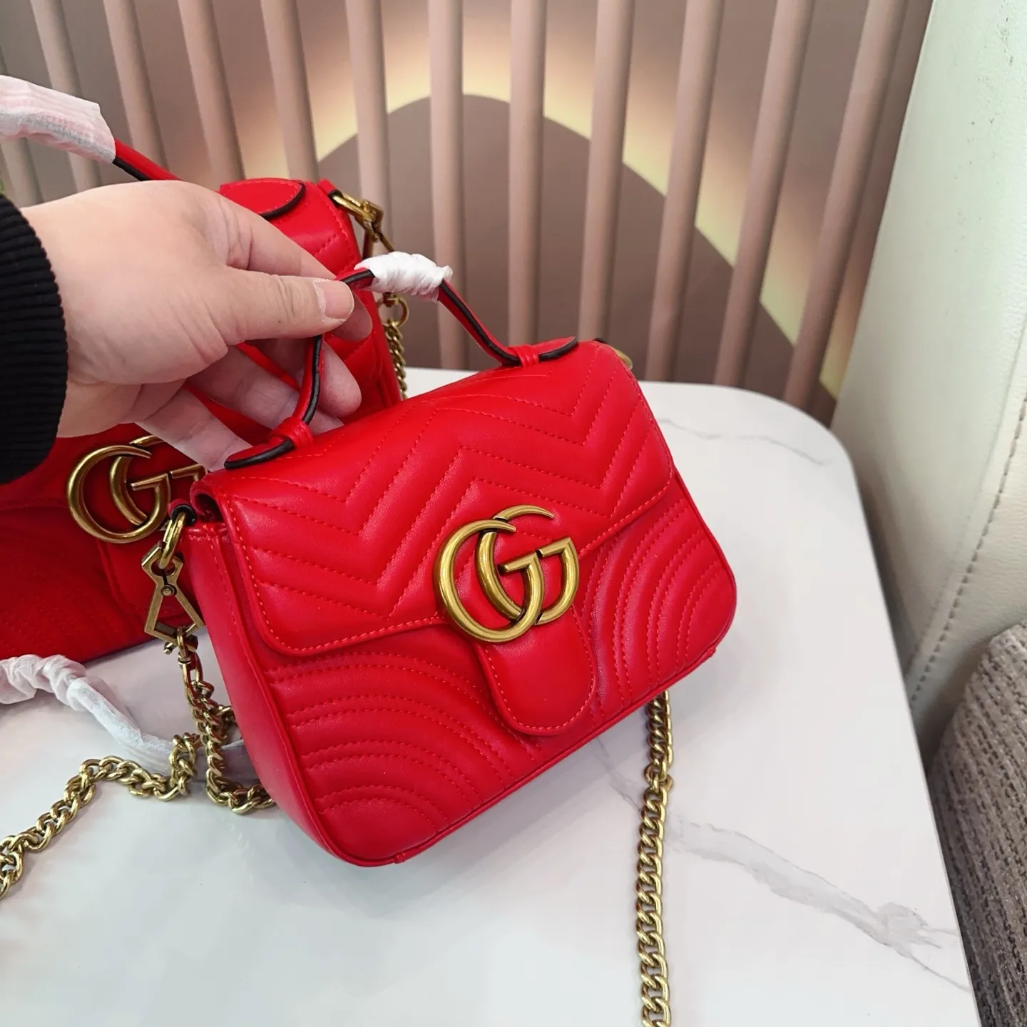 大号p125小号p120 折叠礼盒 Gucci Marmont 邮差包 系列链带肩背包采用颇具结构感的柔软造型和超大号翻盖封口，配以双 G 金属配件。可滑动链条肩带有多种背法，可在肩背和手提之间自由转换。采用波浪纹绗缝皮革，背面配以 GG 标志专柜热销爆款[色]尺寸大号 27 16cm/小号21 15cm。Q