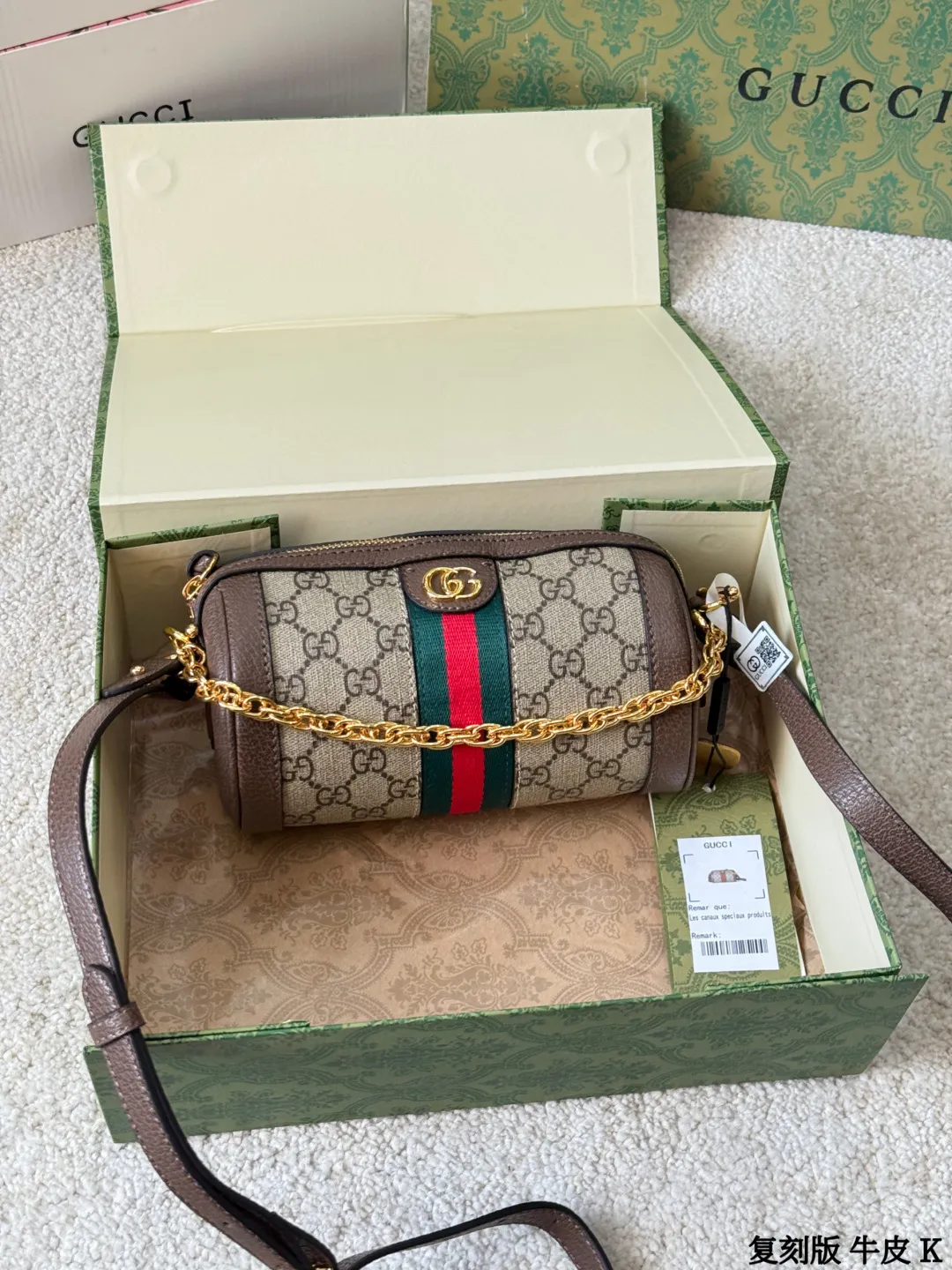复刻版 牛皮 p135 Gucci Ophidia 系列圆筒包 Gucci Ophidia圆筒包,米色乌木GG Supreme帆布+棕色皮革滚边,红绿织带+金色配件,复古感满满!18.5x10x10cm18.5x10x10cm,小巧可爱,通勤出行都很适合 。两条可拆卸肩带,链条or皮质随心切换,拉链开合更安全。内部虽小但能装下日常小物,实用又有辨识度