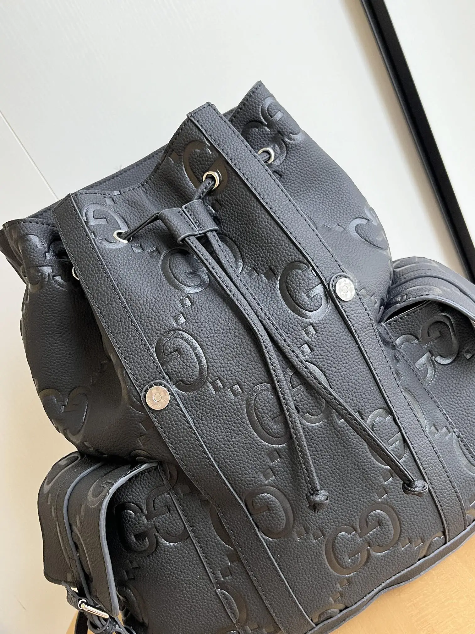 实拍#💰280 款号：625770 34x41x12cm：34x41x12cm 以其柔软和稍微有光泽的完成而闻名，gg 皮革在今年秋季前的系列中运用了纹理，在黑色穿孔皮革基座上压花了房子的徽章。 这款背包有多个外部和内部口袋，包括一个带衬垫的笔记本电脑包和智能手机套。 功能性的带扣关闭器有额外的磁扣，可以方便地打开。