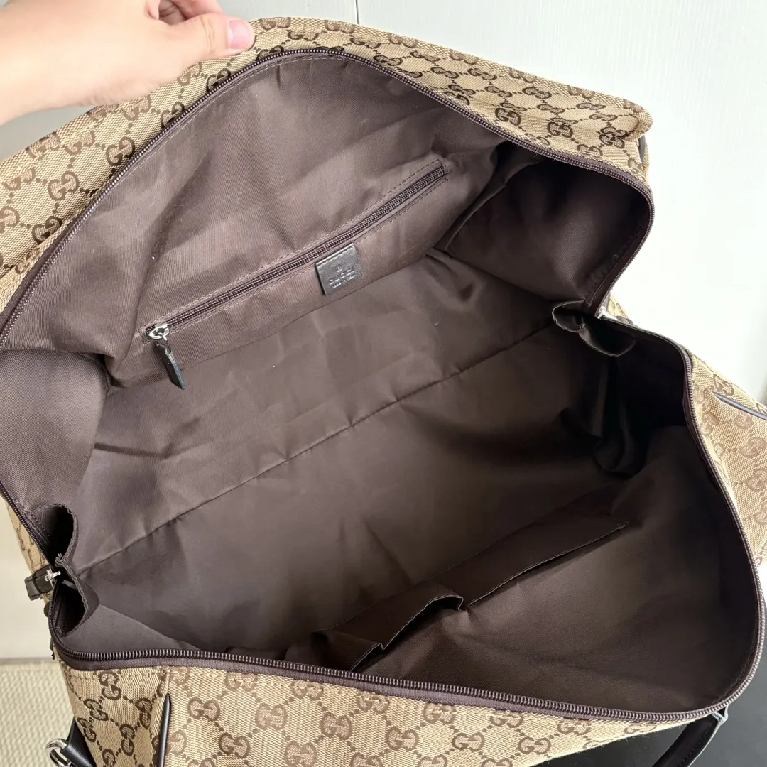 实拍#💰280 款号:802095 尺寸:45/28/24cm 秋冬男士系列经典旅行单品生动展现运动风格。该系列旅行单品采用OriginalGG帆布制作,经典配饰搭配甄选配色,织带和压花标识等精致细节传递时尚气息。这款旅行包以米色和乌木色帆布打造,搭配一个外部口袋、顶部提手和D形环。