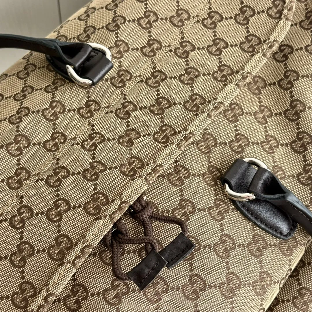 实拍#💰280 款号：802095 尺寸：45/28/24cm 秋冬男士系列经典旅行单品生动展现运动风格。该系列旅行单品采用OriginalGG帆布制作，经典配饰搭配甄选配色，织带和压花标识等精致细节传递时尚气息。这款旅行包以米色和乌木色帆布打造，搭配一个外部口袋、顶部提手和D形环。